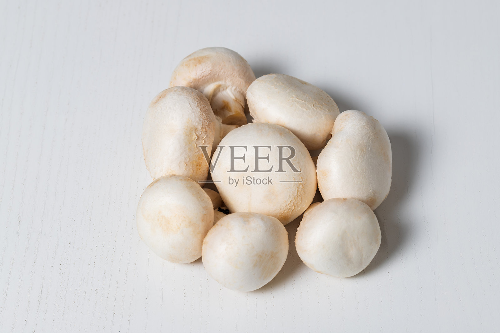 白色的香菇被隔离在一张白色的桌子上。照片摄影图片