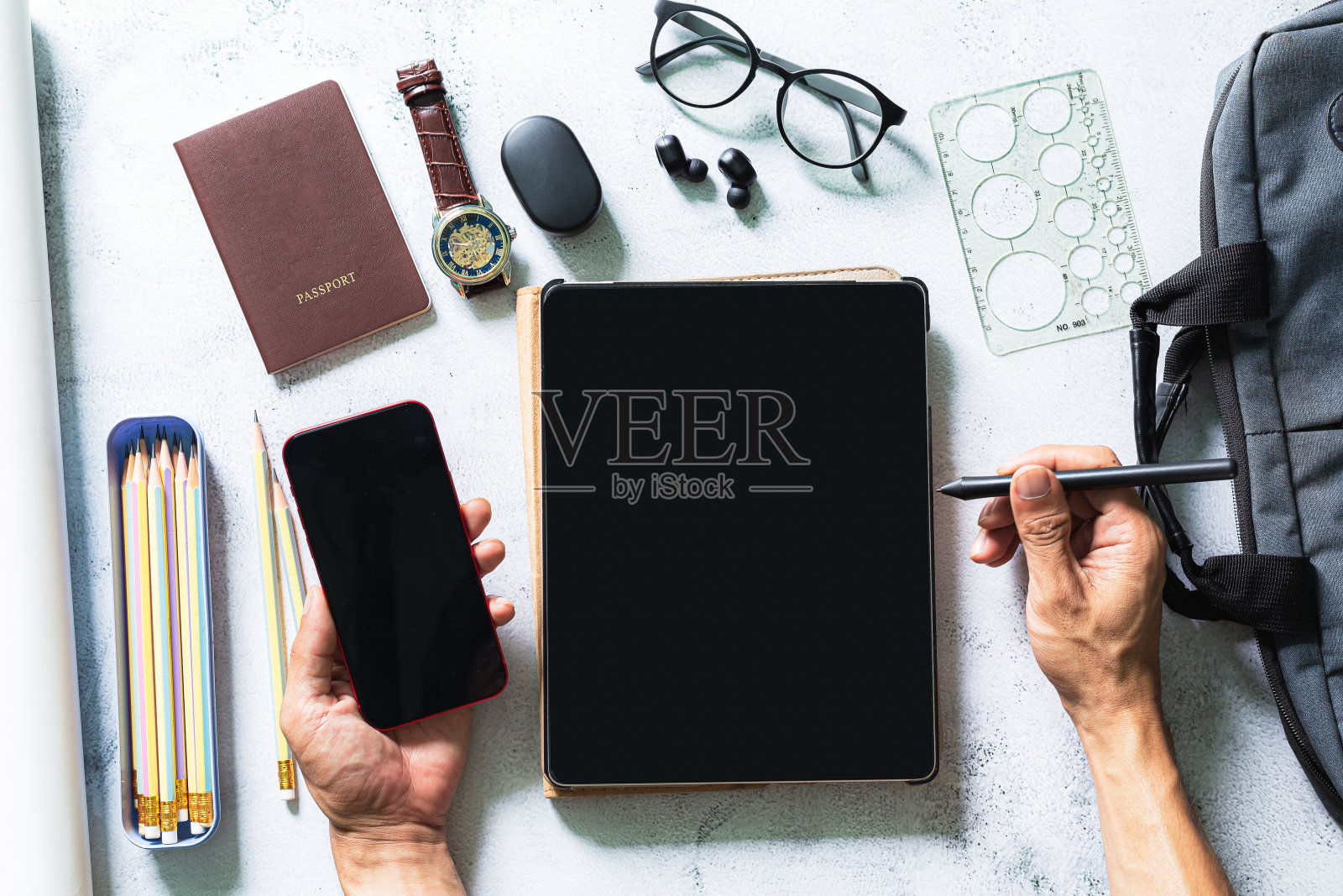 在白色办公桌上的平板电脑屏幕上工作，从俯视图可以看到商务人士用白色办公桌上的数字设备模型、用品和装饰品为他们的项目进行头脑风暴照片摄影图片