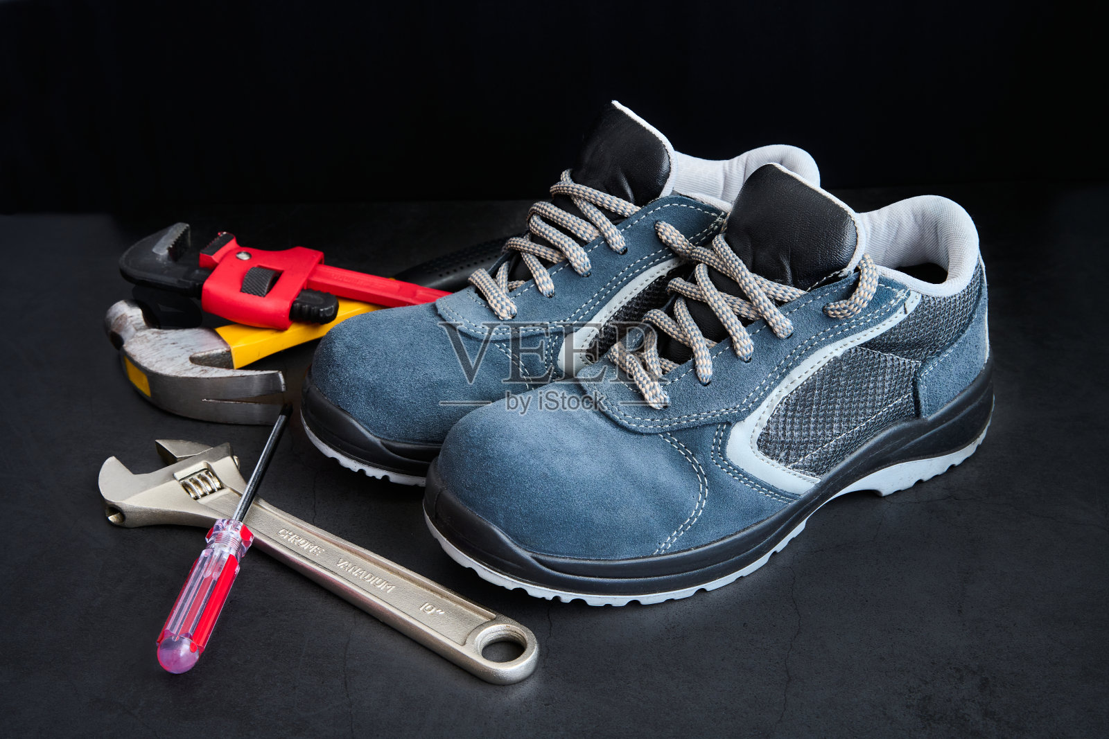 一双安全鞋，锤子，螺丝刀和扳手在黑色背景照片摄影图片