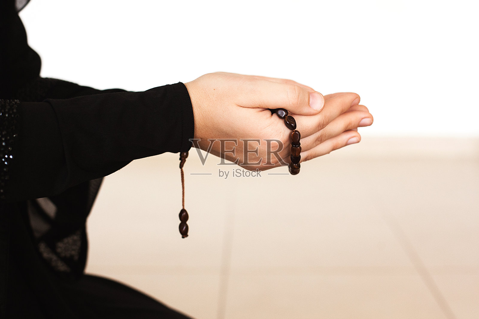 手握念珠祈祷的女人照片摄影图片