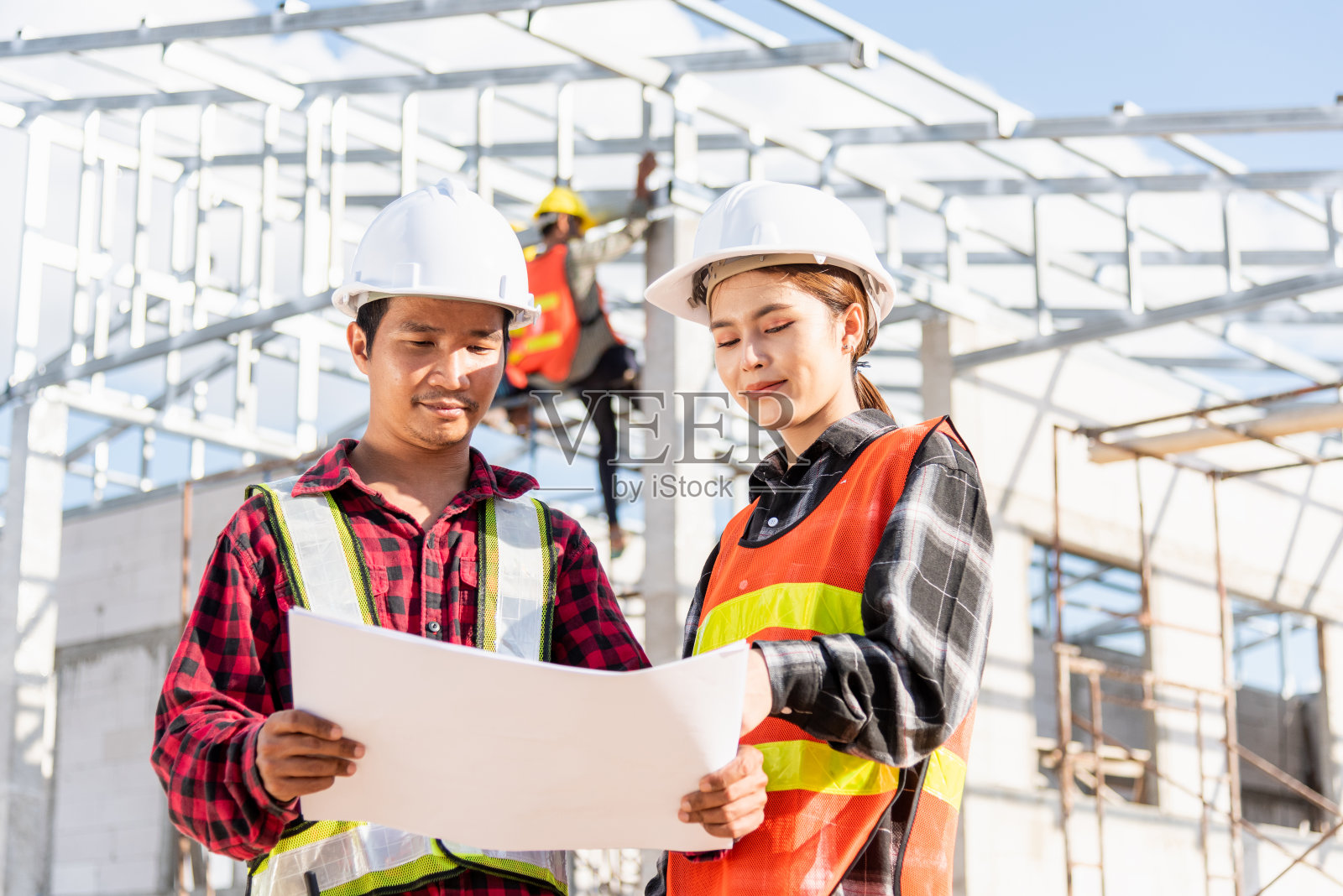 两名建筑师和客户讨论帮助在施工现场创建计划和蓝图家建筑照片摄影图片