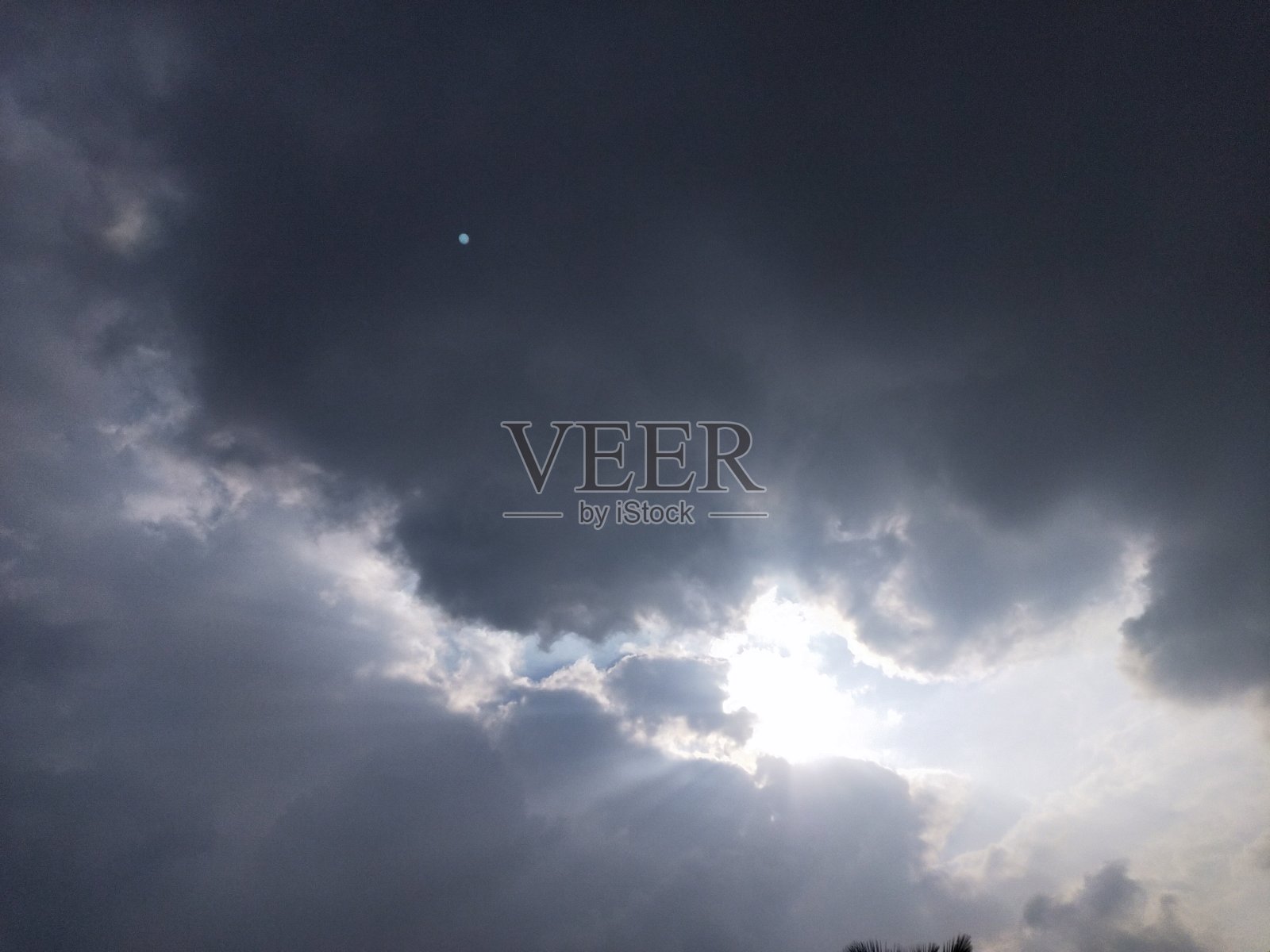 阳光冲破了灰黑色的积云照片摄影图片