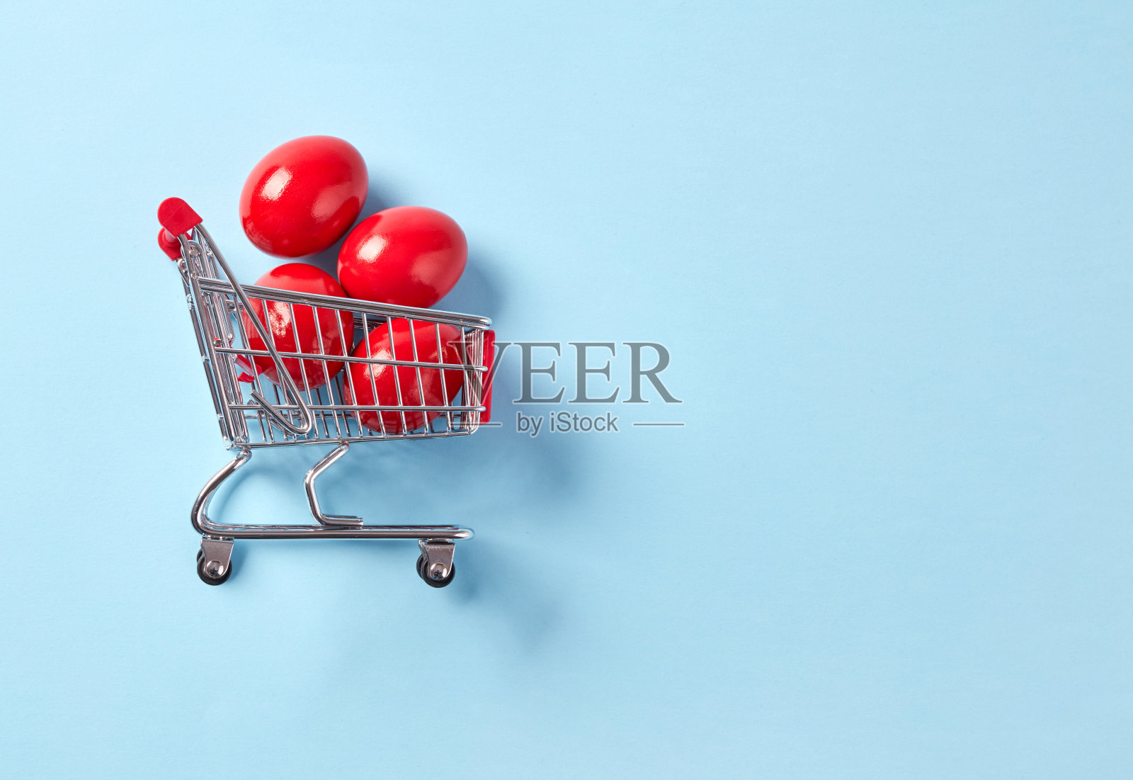 装有红色复活节彩蛋的购物车照片摄影图片