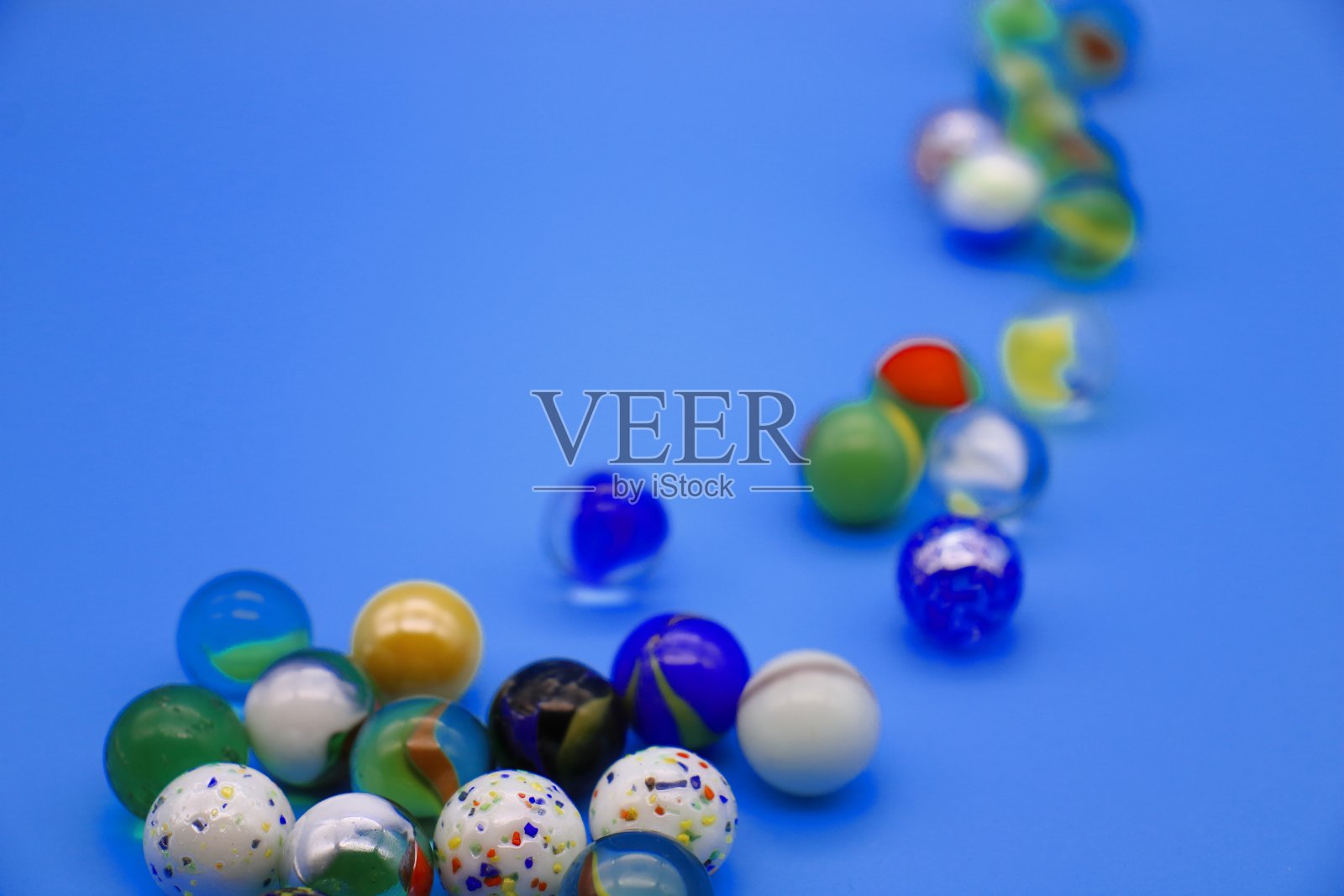 蓝色背景的彩色玻璃弹珠照片摄影图片