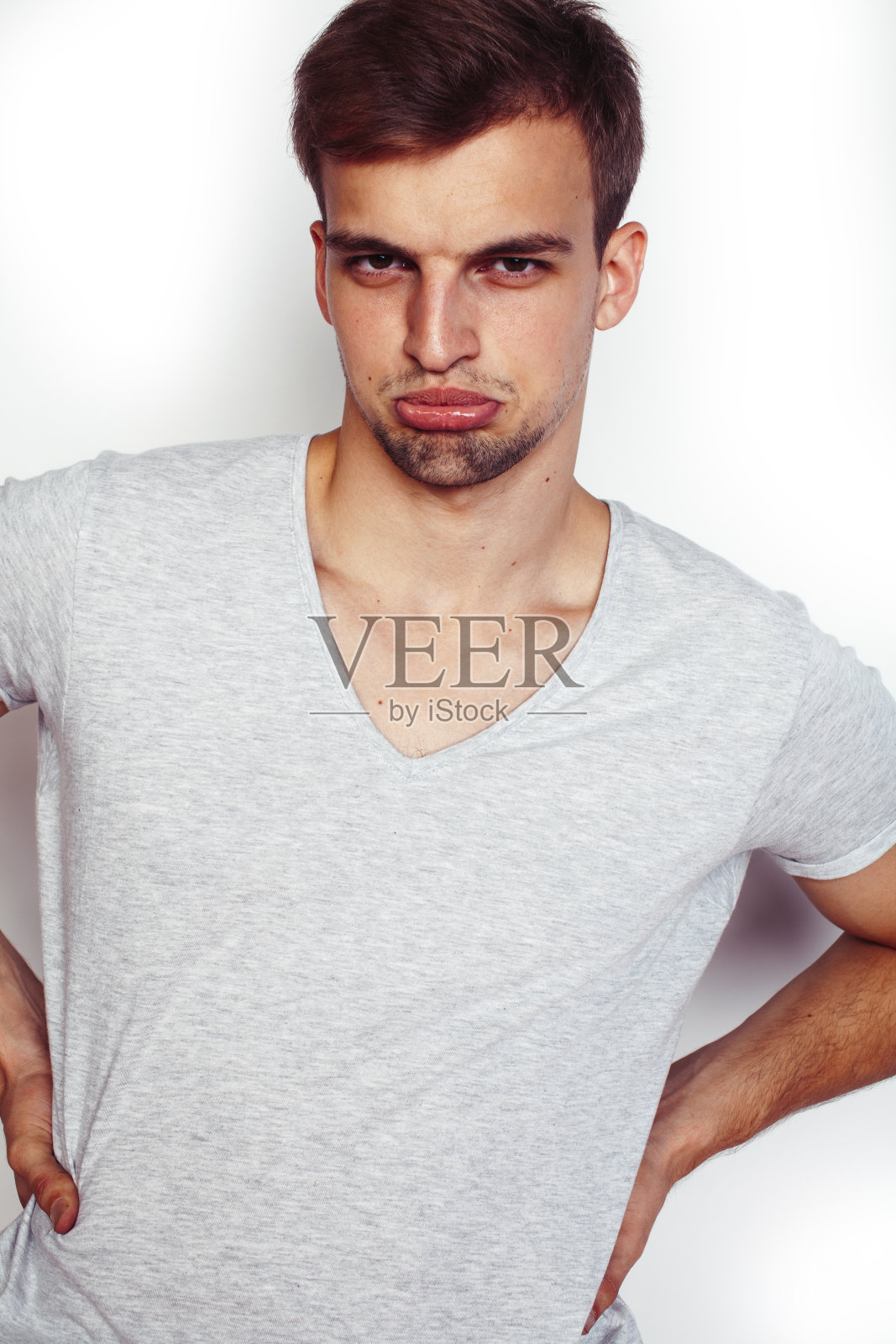 年轻帅气的十几岁潮男摆着情感的姿势，开心的微笑着在白色的背景下孤立，生活方式的人的概念照片摄影图片