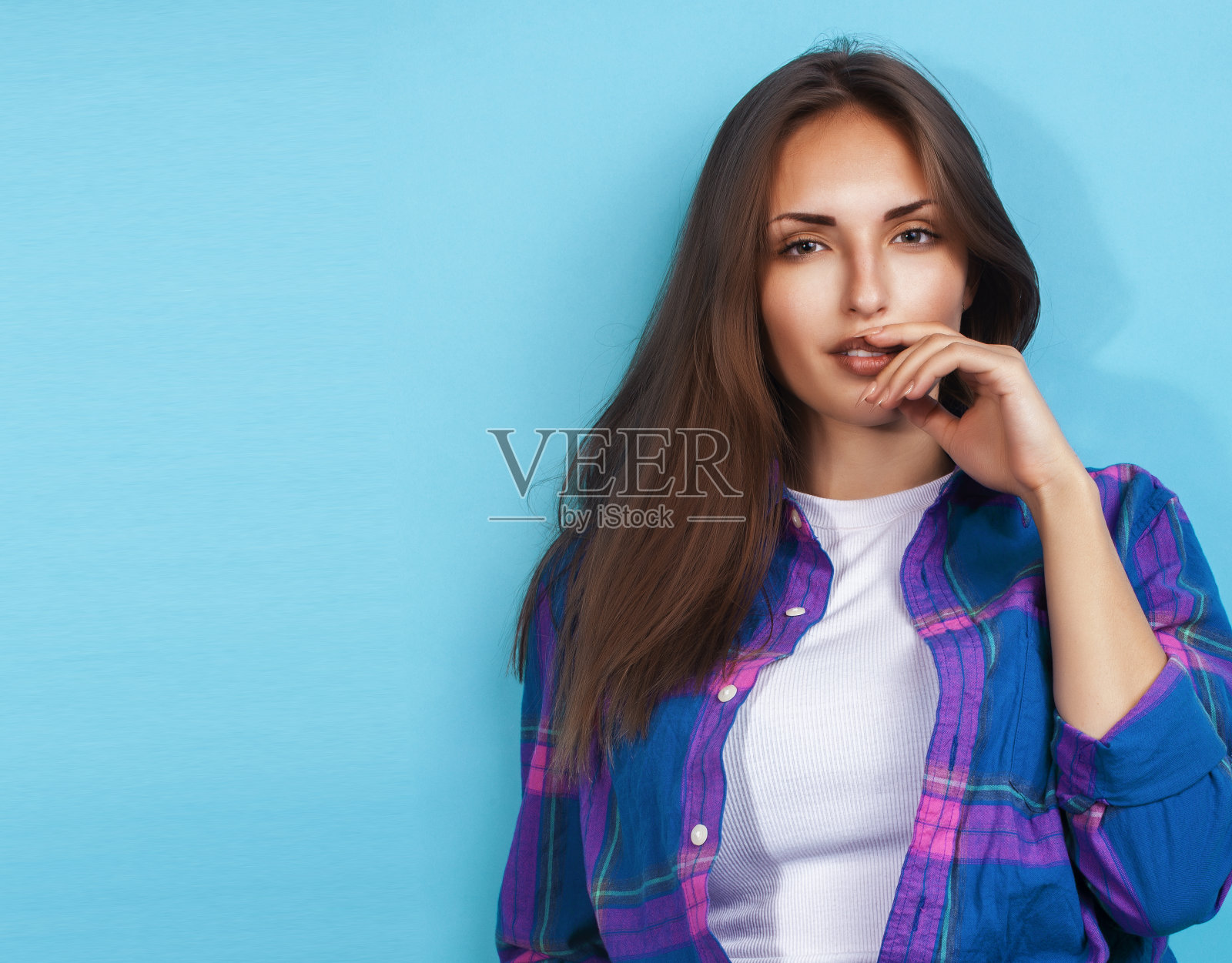 年轻漂亮的时髦女孩摆出情绪快乐的蓝色背景，生活方式的人的概念照片摄影图片