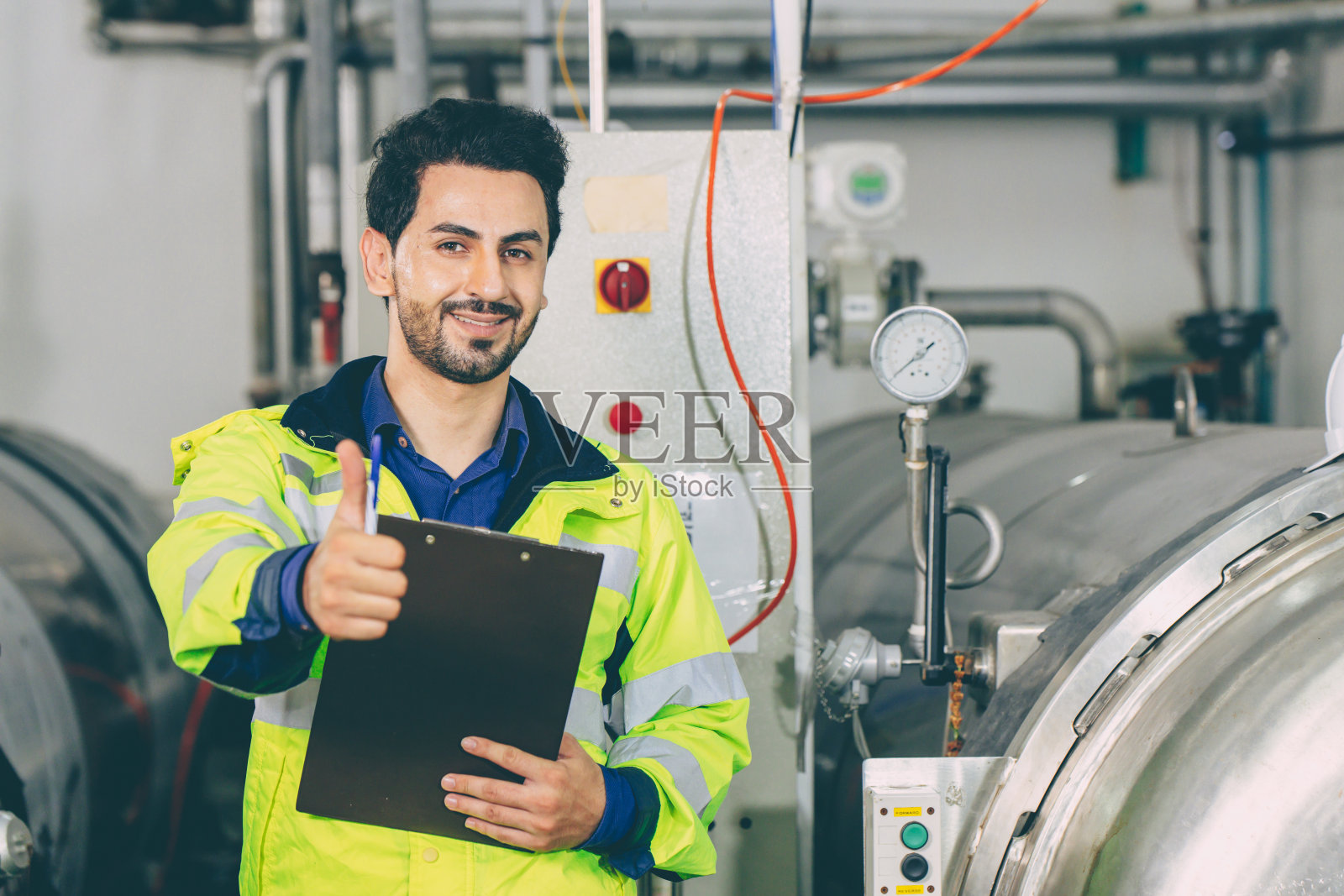 拉丁聪明的工程师开心的笑着竖起大拇指在工厂工作照片摄影图片