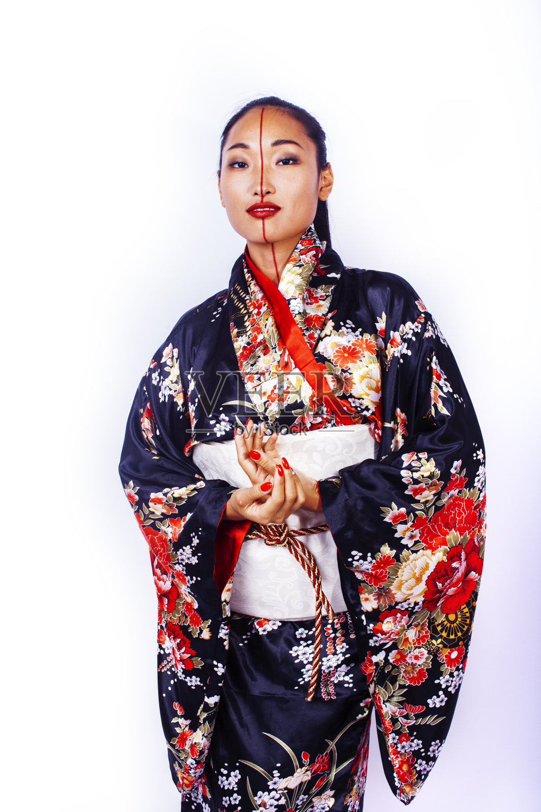 年轻漂亮的艺妓穿着黑色和服在白人背景下摆姿势，亚裔照片摄影图片