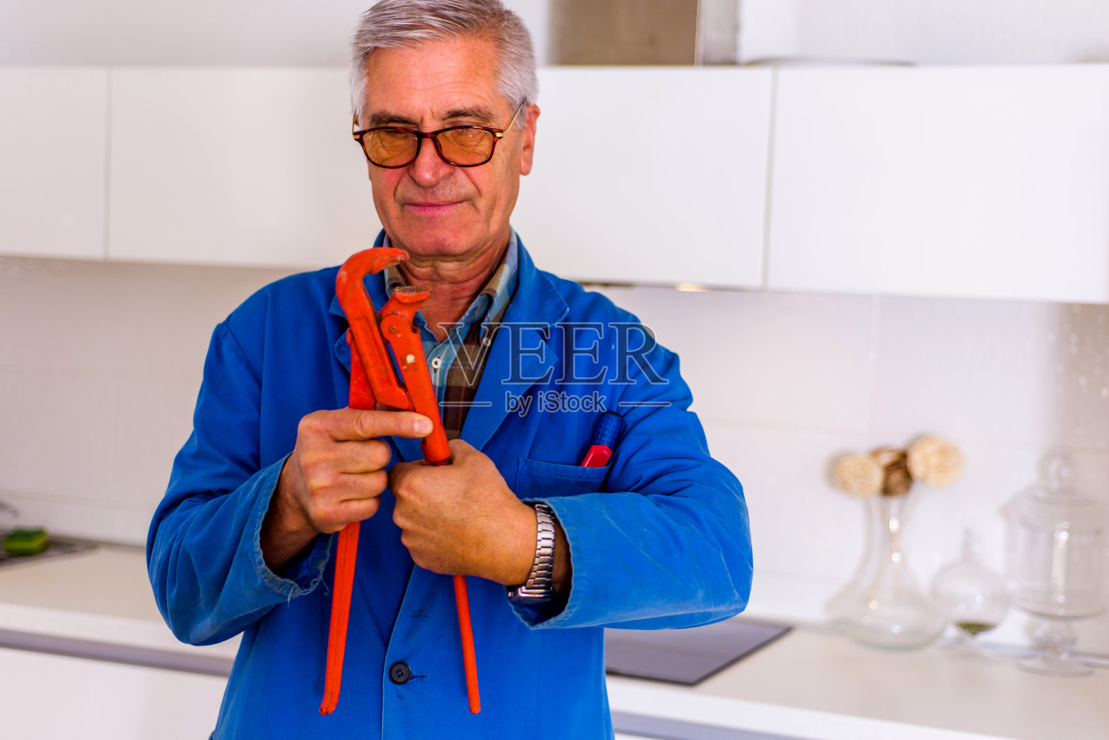 穿蓝色制服的杂工拿着工具工作照片摄影图片