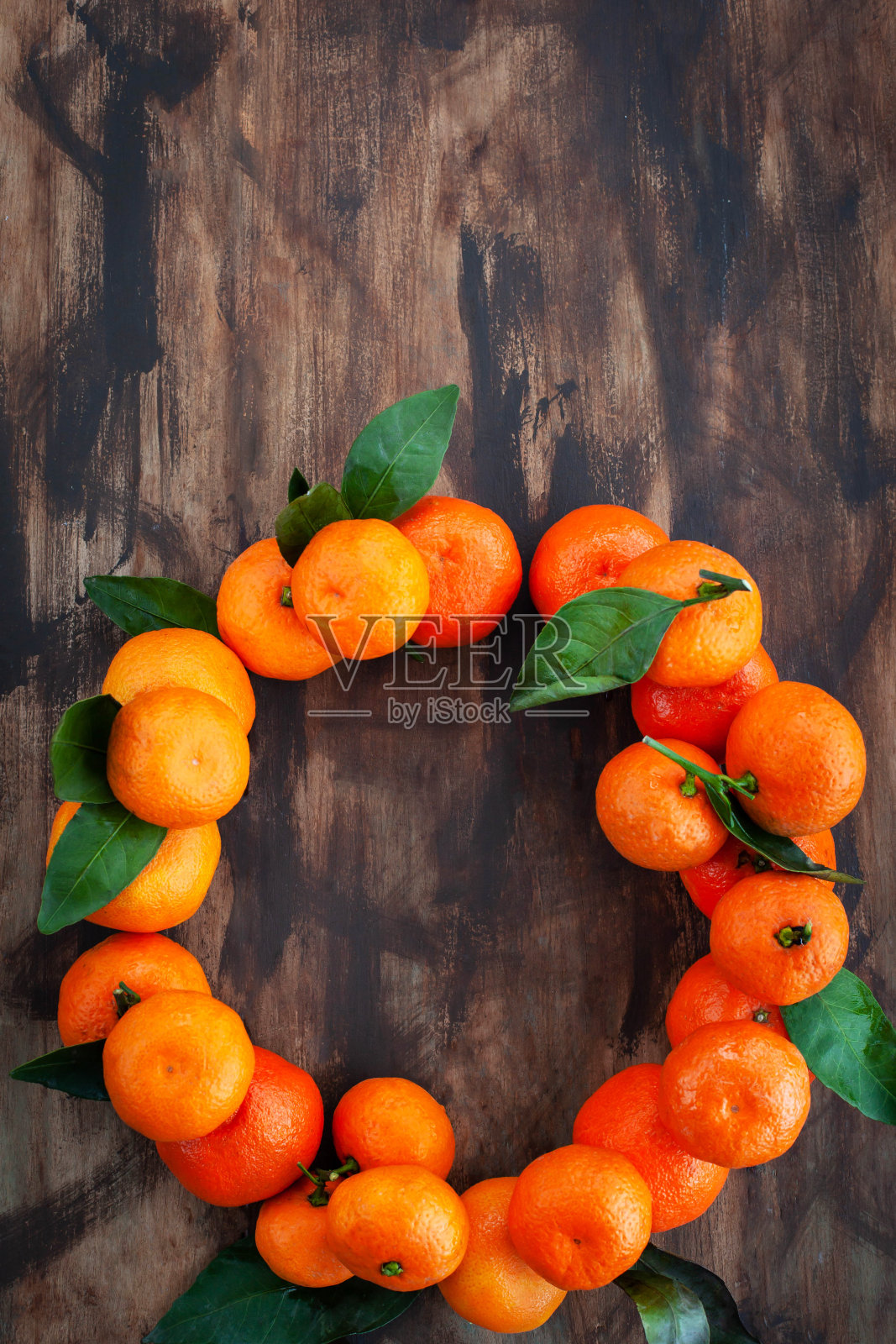 新鲜成熟的柑橘花环与树叶木制背景，俯视图，复制空间照片摄影图片