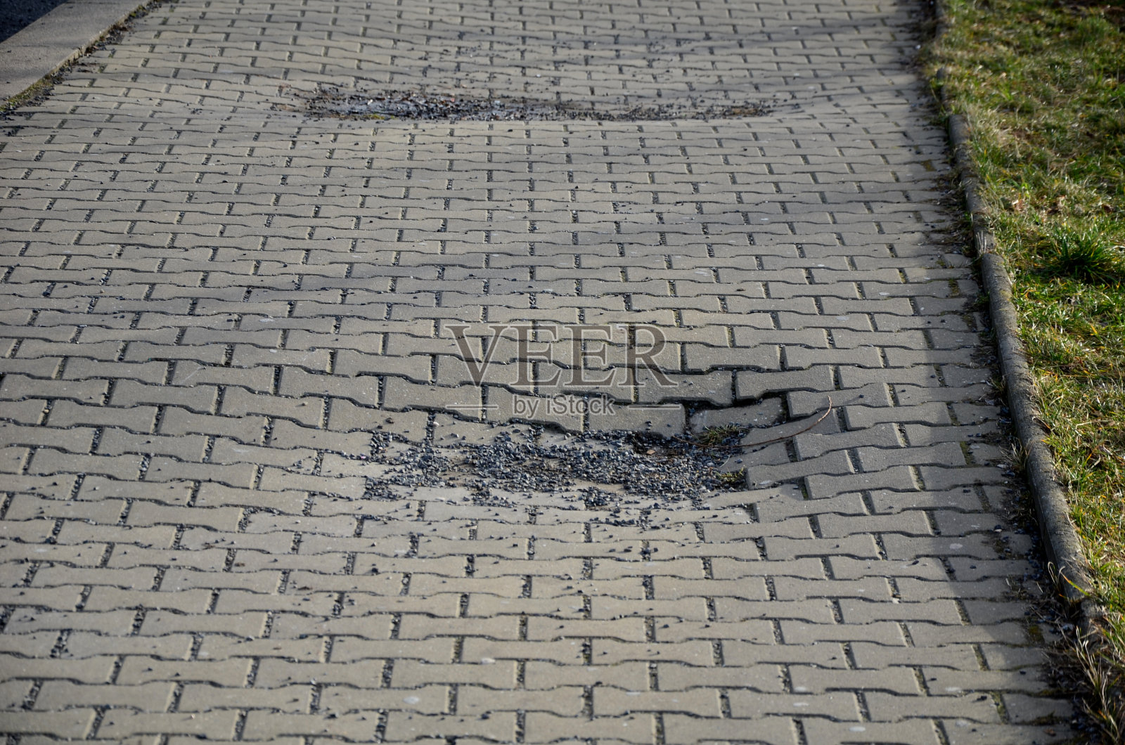 斜坡和人行道上的涟漪。下水道损坏，振动压路机压实不良，造成混凝土瓦表面损坏。施工道路开始前应进行耐压试验照片摄影图片