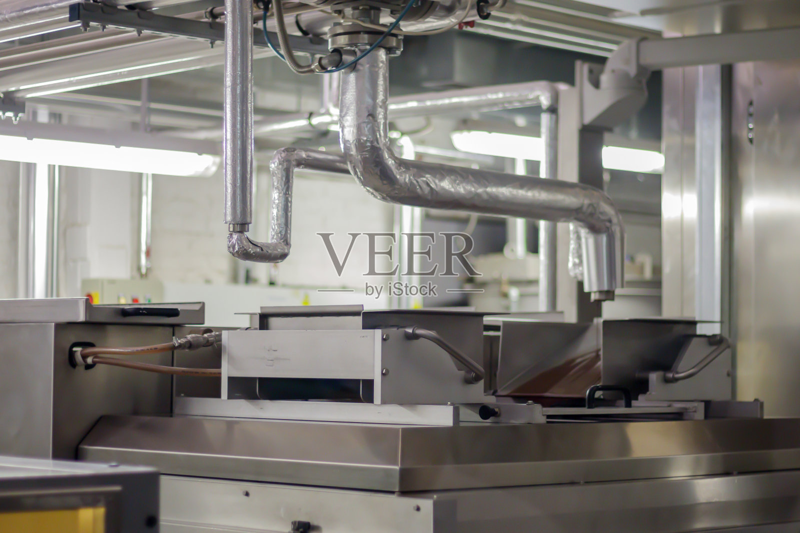 一家工业工厂生产巧克力的生产线。糖果生产线的自动化加工。巧克力工厂生产过程中的图片。带糖果的输送带照片摄影图片