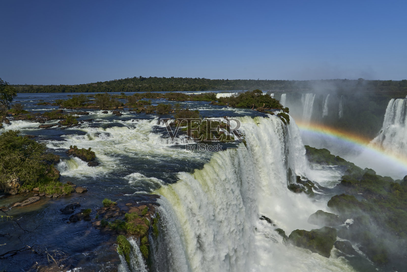 位于阿根廷和巴西边界的伊瓜苏瀑布是世界上最大的瀑布。非常高的瀑布和白色的水在美丽的热带雨林景观的丛林照片摄影图片