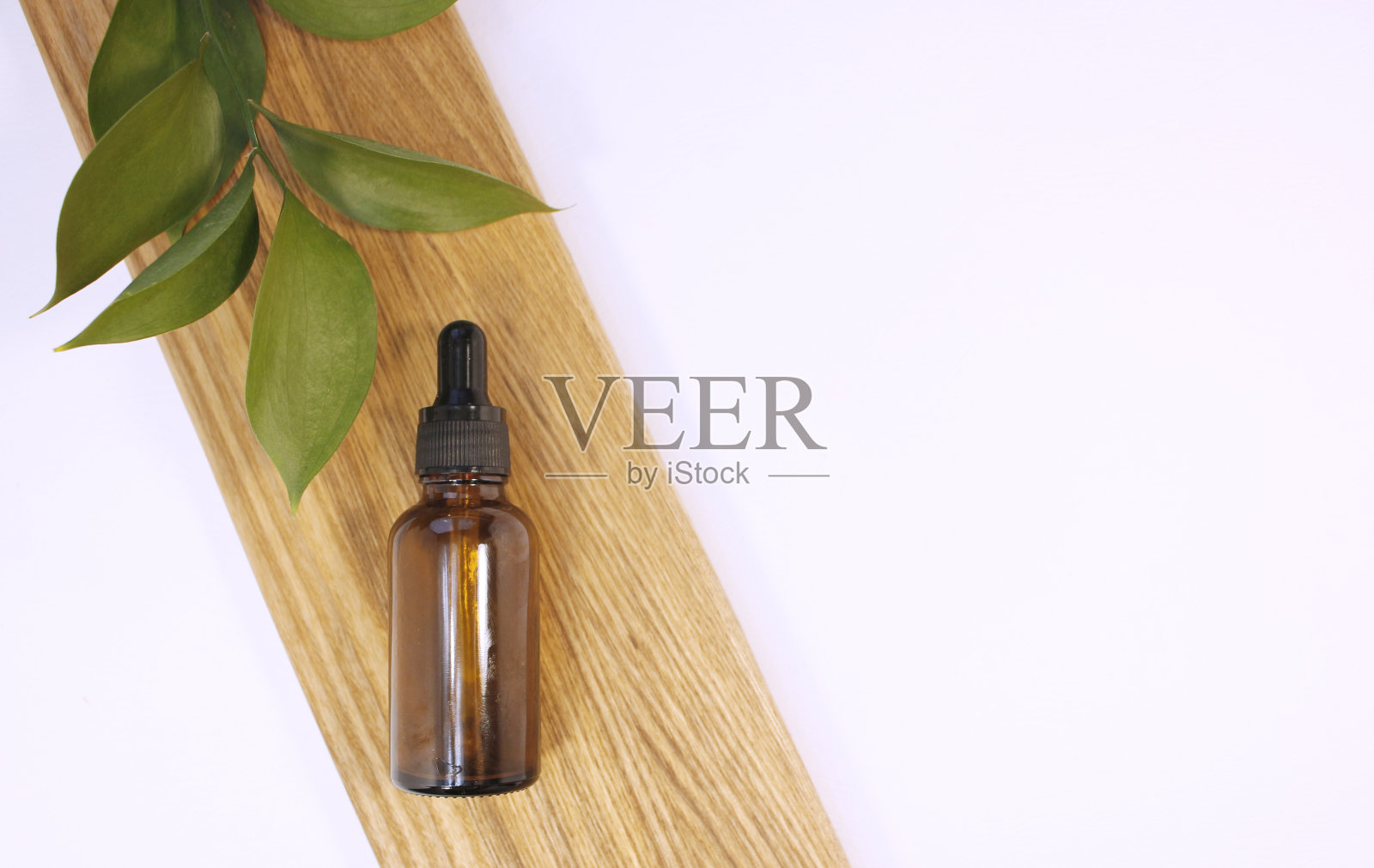 天然精油或精华液，装在棕色玻璃瓶中，放置在木质平台上。替代医学，美容护肤产品。副本的空间。中性的背景照片摄影图片