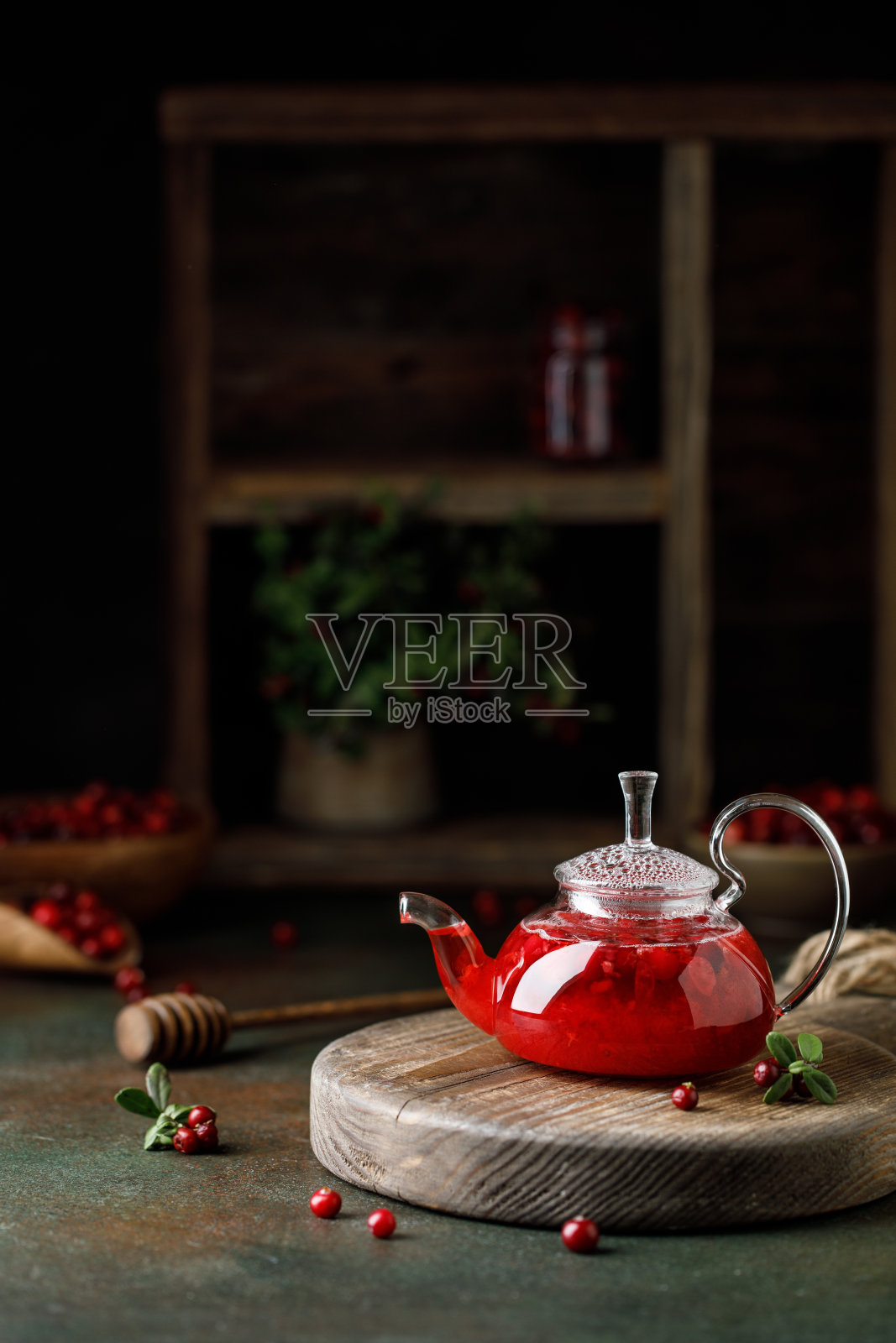 热越橘饮料在玻璃茶壶。越橘茶在茶壶照片摄影图片