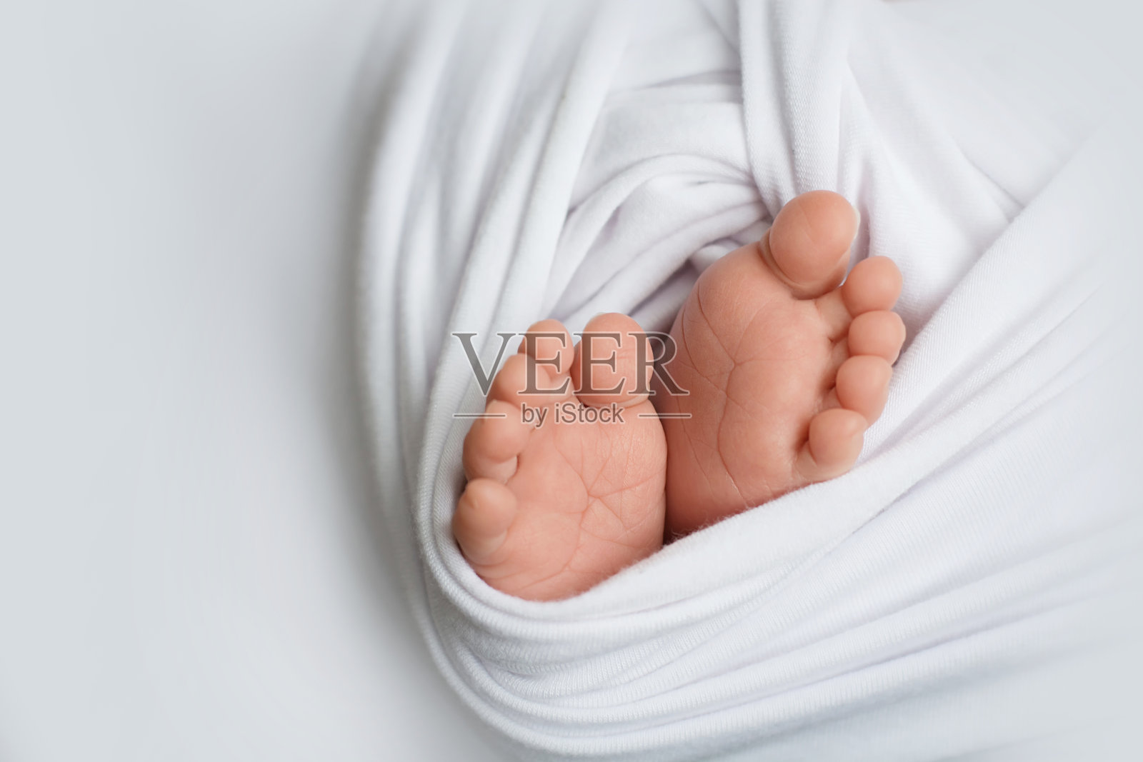 新生婴儿的脚在白色的背景照片摄影图片