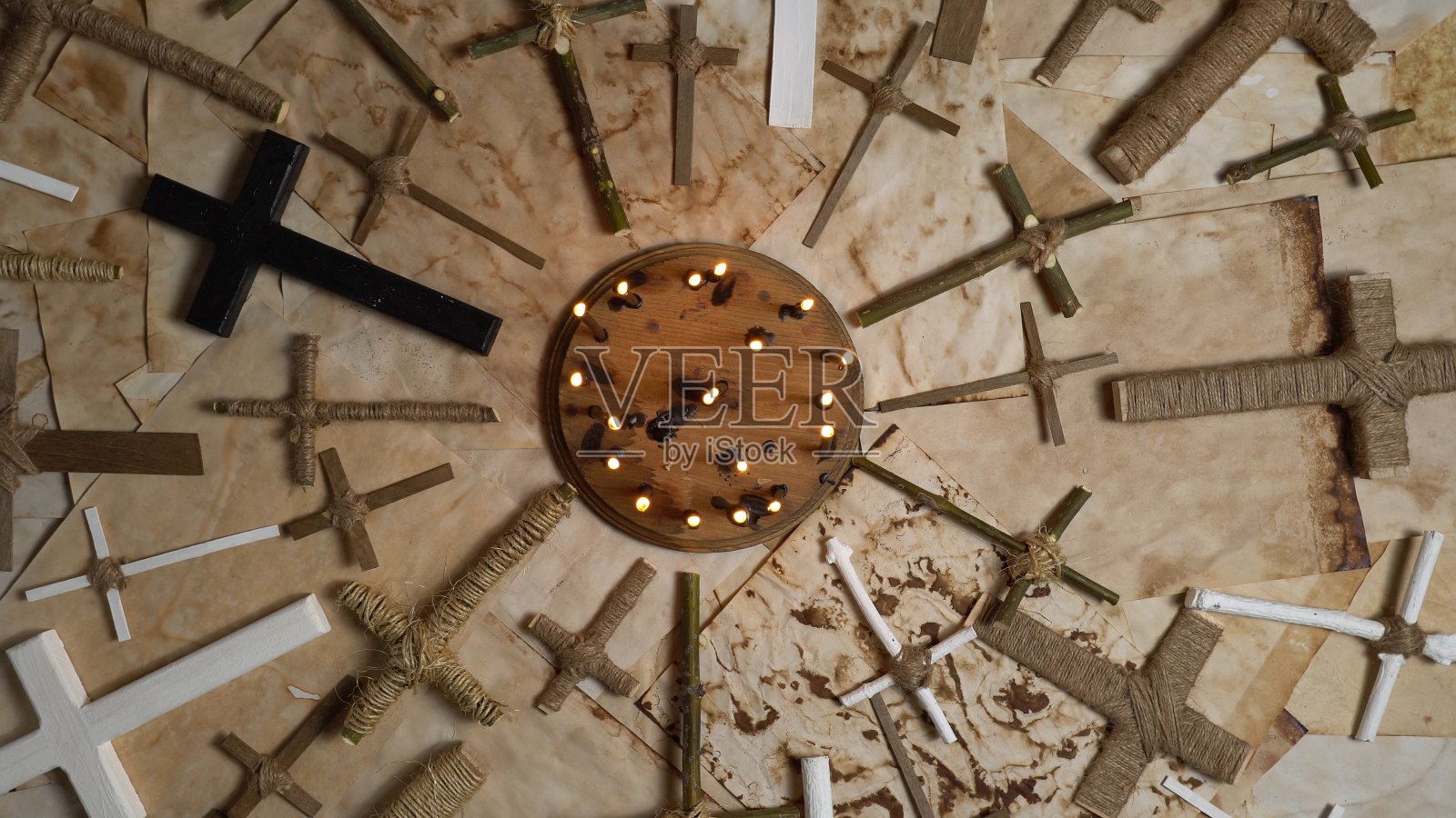 木制十字架十字架在古老的羊皮纸上。手工宗教基督十字架的物品由森林树枝和棍子。耶稣基督的上帝之子在古老的风化的烧焦的纸上祈祷。照片摄影图片