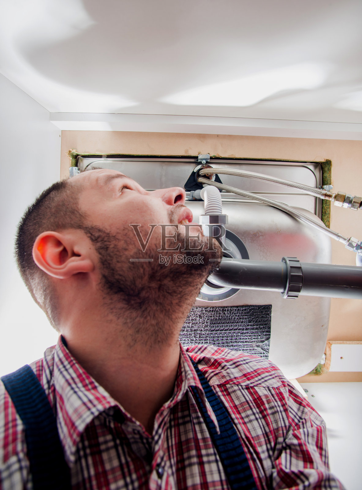 水管工在水槽里寻找问题照片摄影图片