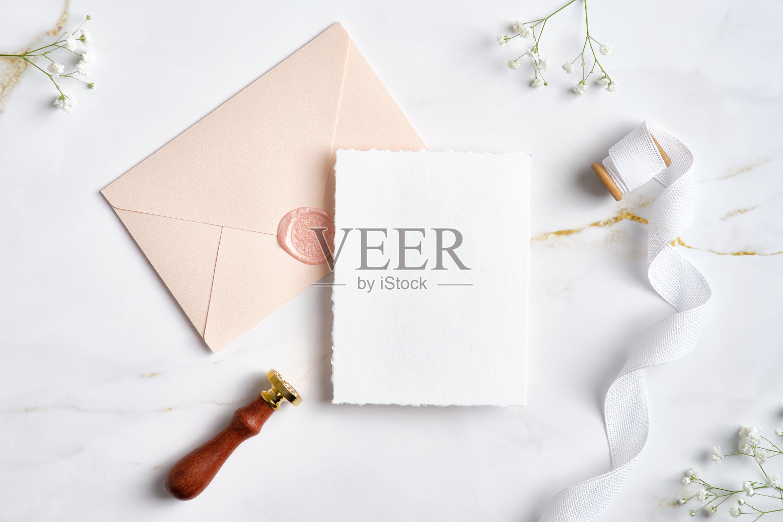 婚礼请柬模型，粉彩除草信封，蜡封邮票，丝带，石桌上的鲜花。除草文具。平躺，俯视图。照片摄影图片