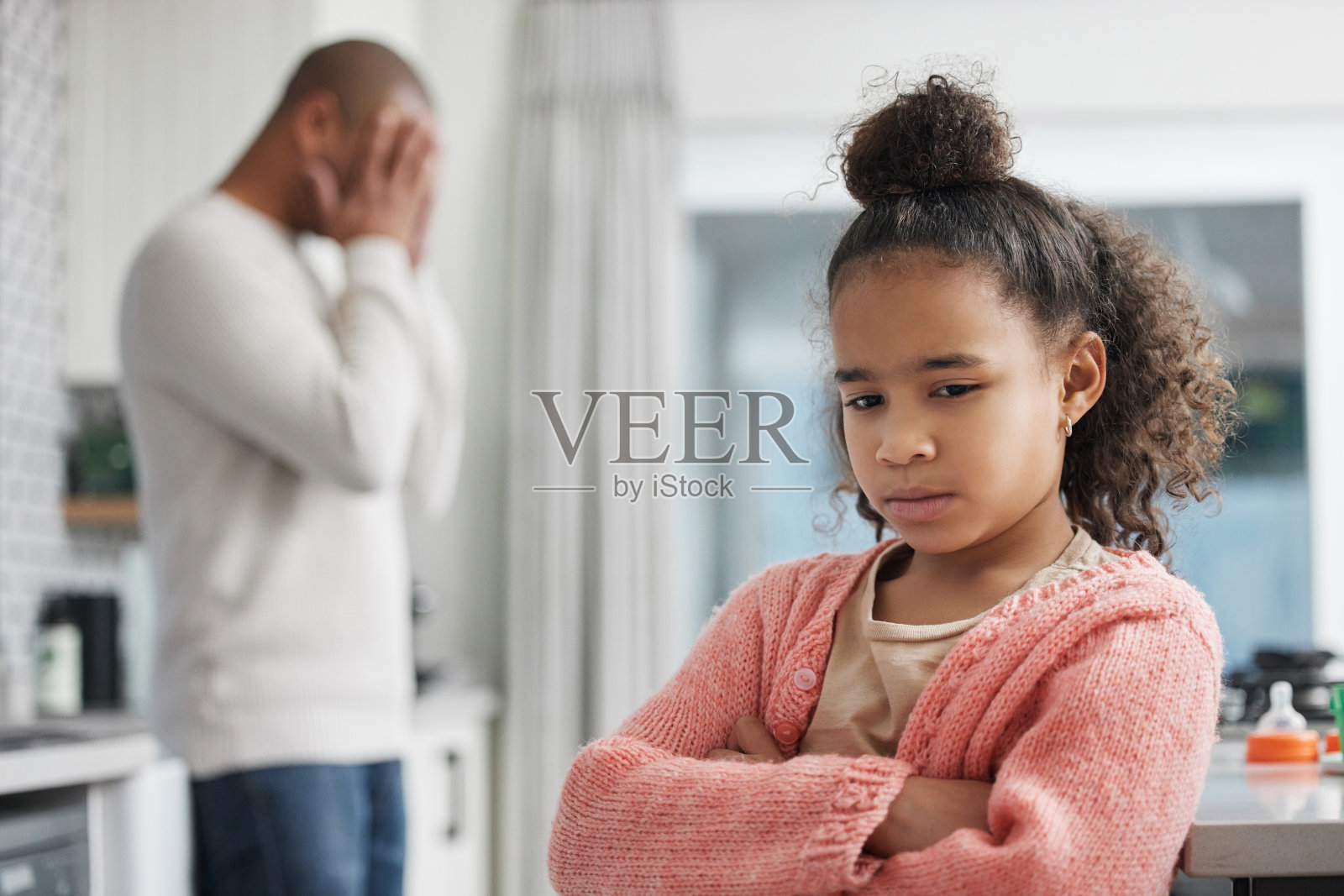 这张照片拍摄的是一个小女孩在家里和父亲发生争执后看起来很不开心照片摄影图片