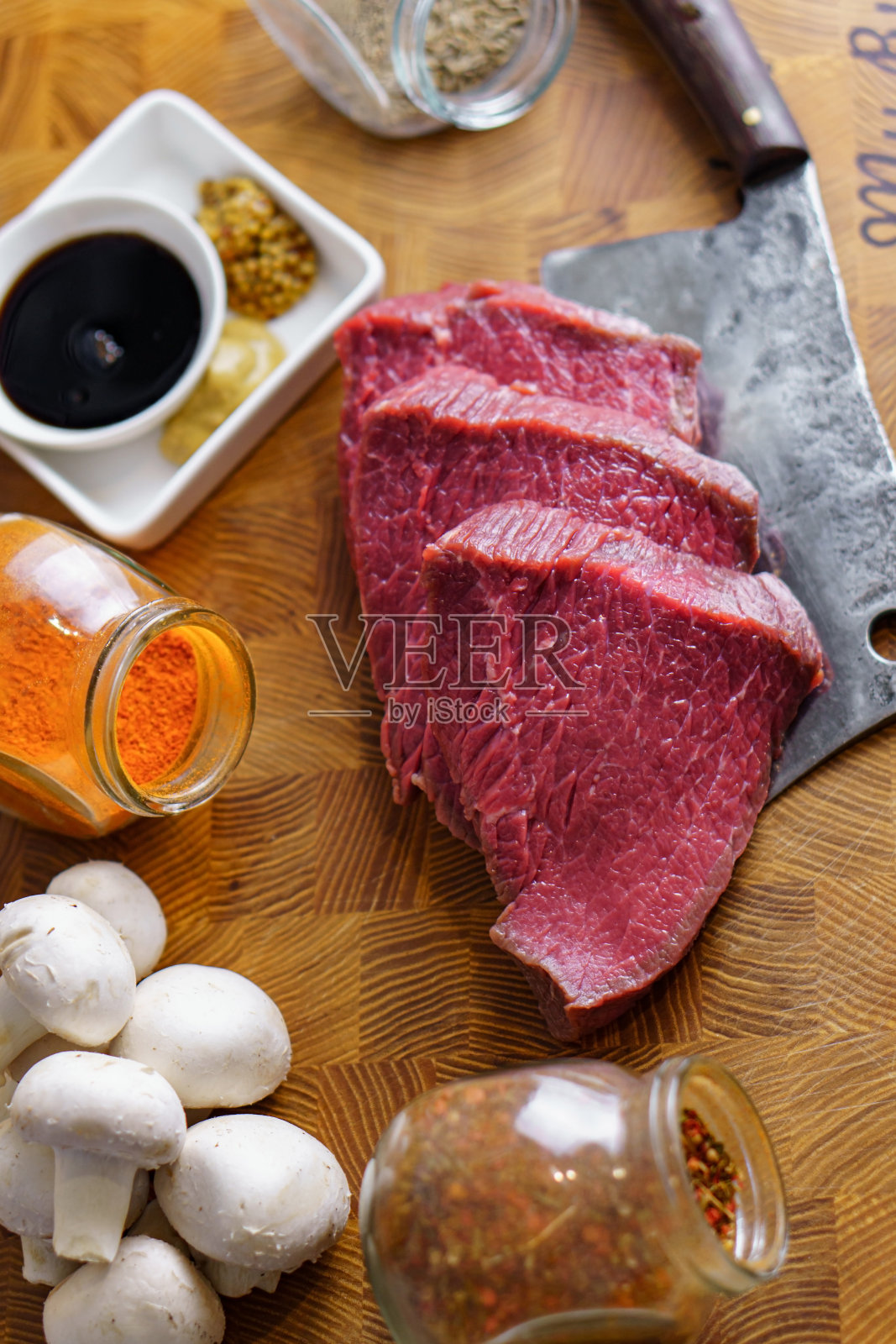 生的准备烧烤牛排刀，蘑菇香料切菜板。健康食品的概念照片摄影图片