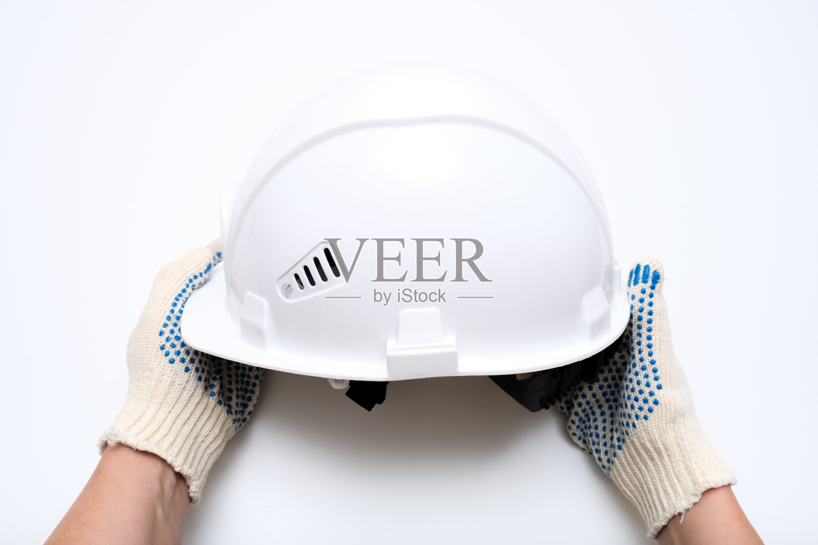 工人手中，建筑工人手持白色防护安全帽，安全帽背对白色背景照片摄影图片