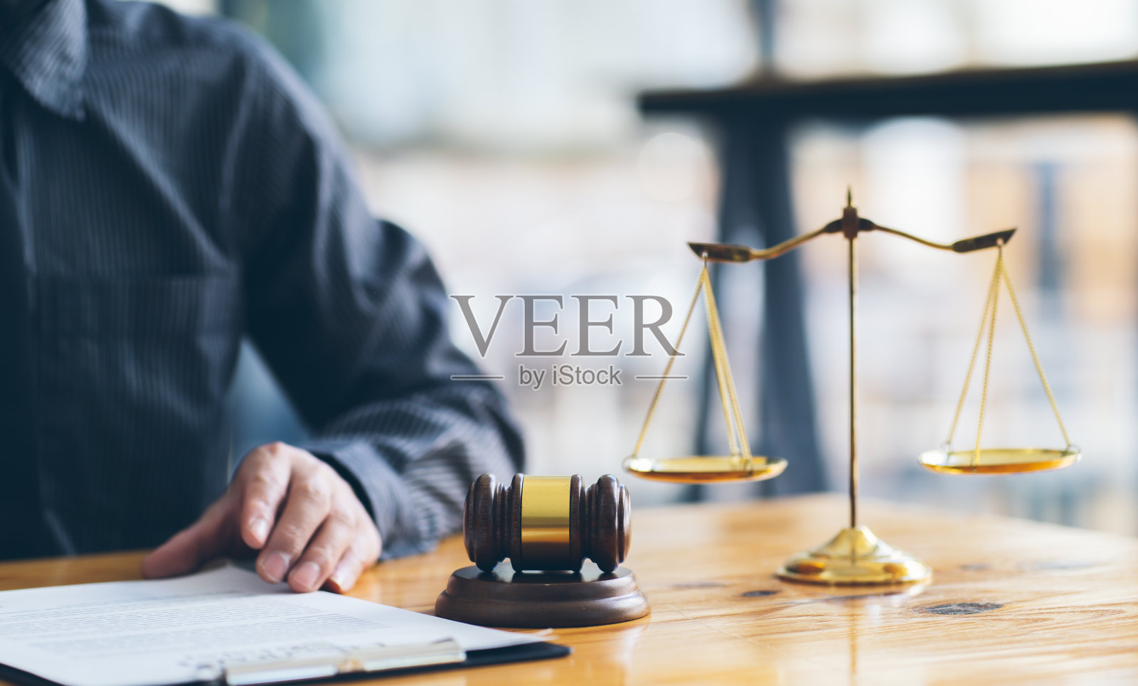 商务人士和律师在办公室的办公桌上用黄铜天平讨论合同文件。法律、法律服务、法律咨询、司法、法律理念。照片摄影图片