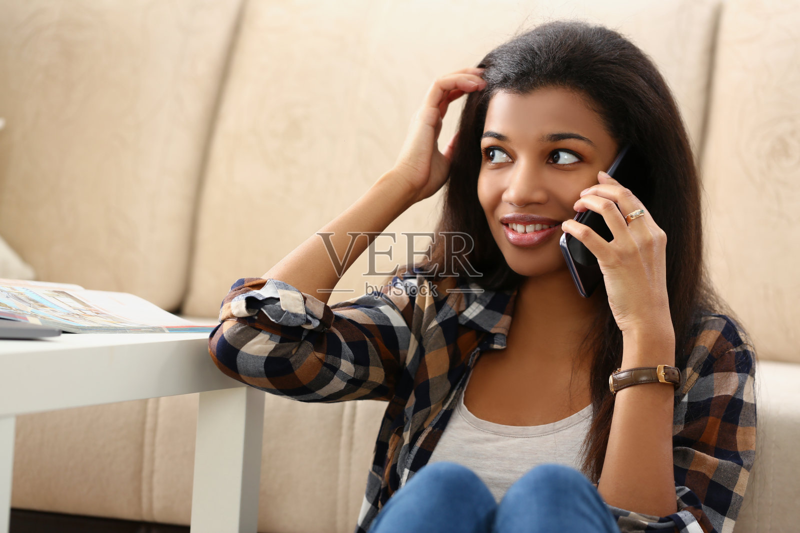 一个深色皮肤的女孩在楼下的房子里讲电话照片摄影图片