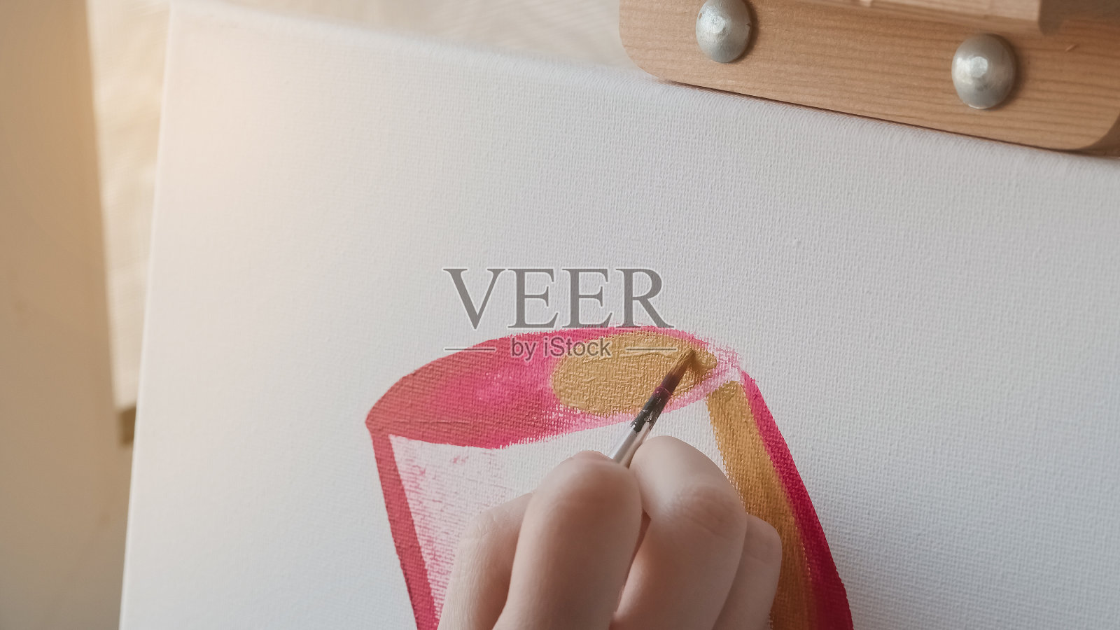 女性用画笔在画布上作画。照片摄影图片