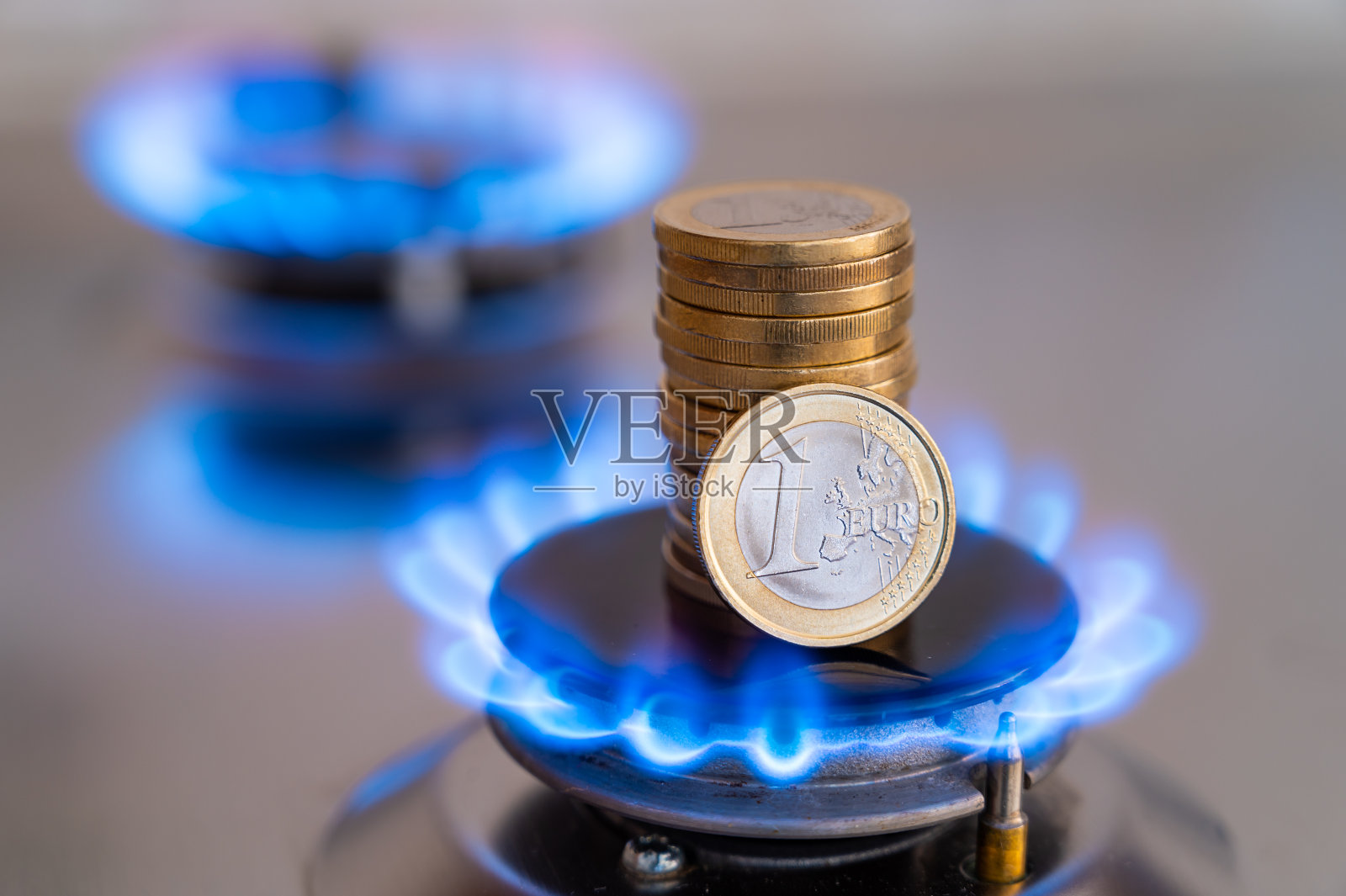 煤气灶上，有硬币。天然气成本。照片摄影图片