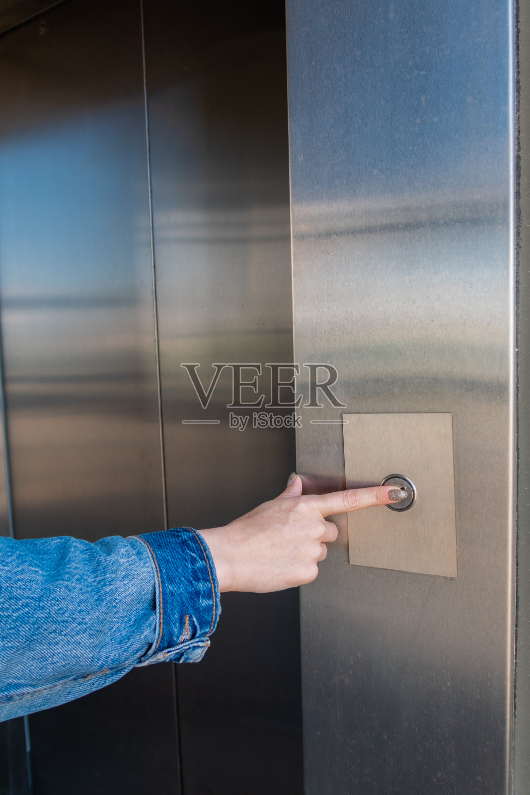 女人用手指叫电梯照片摄影图片