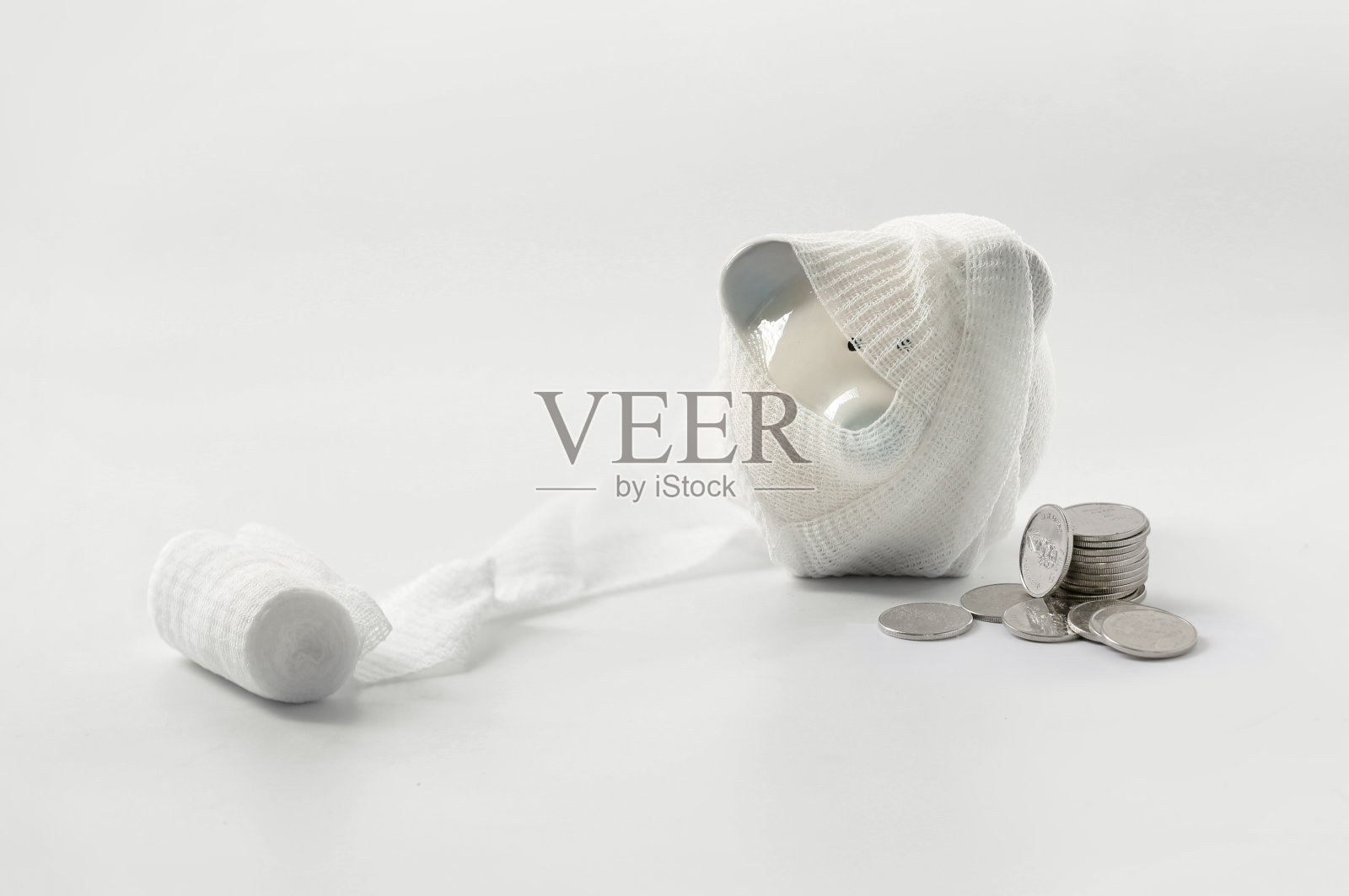 带绷带的小猪存钱罐，泰铢硬币，存钱概念健康保险和家庭意外保险照片摄影图片