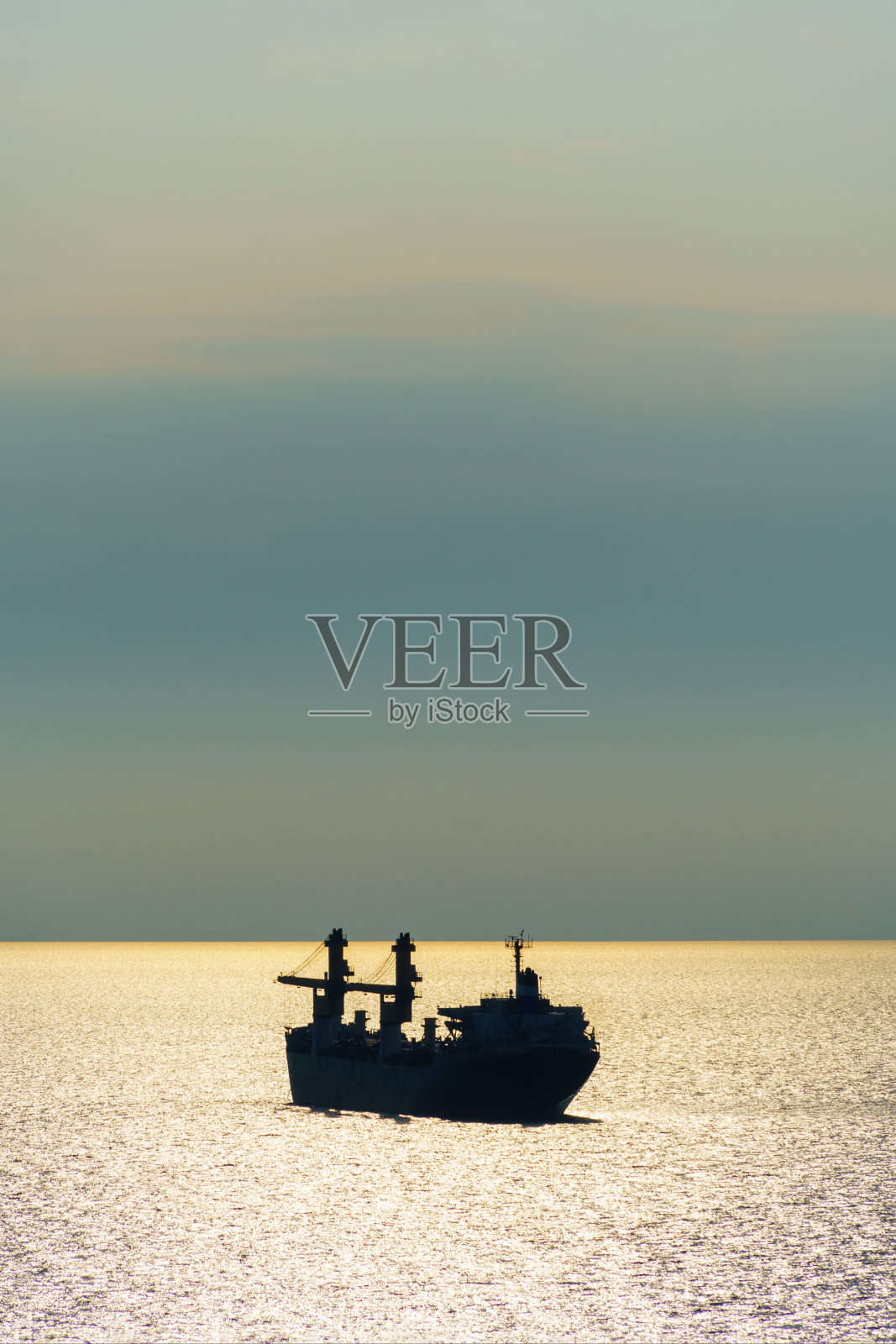 船在海上的剪影，日落天空的壮观海景，明亮的阳光从海浪上反射出来照片摄影图片