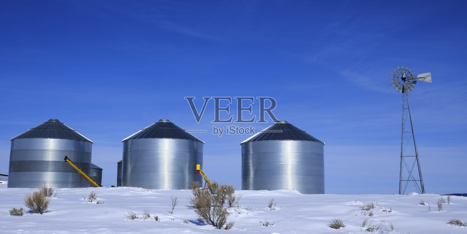 农场冬雪中的风车和粮仓照片摄影图片