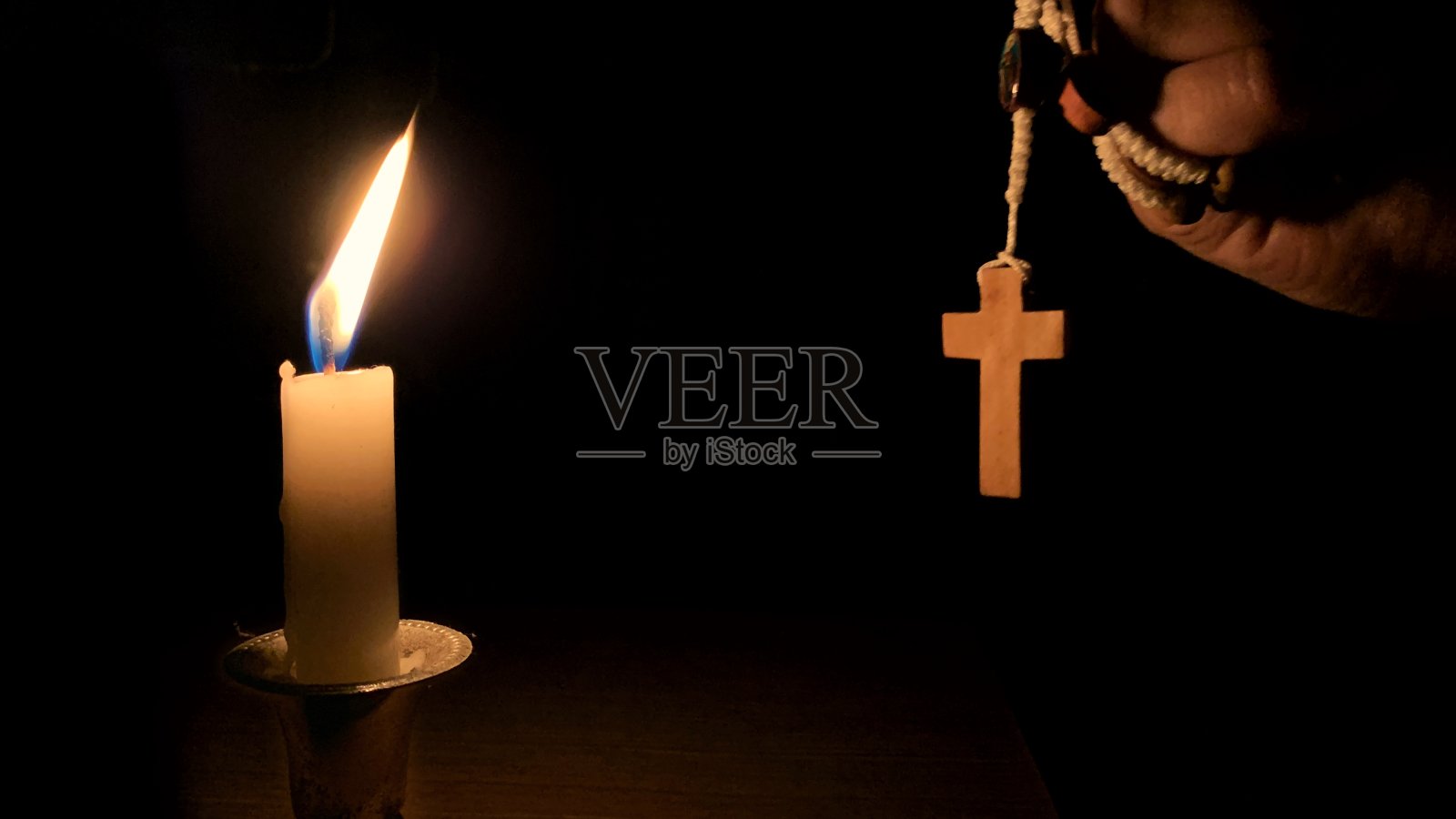 基督教祈祷-神圣的玫瑰经和蜡烛与夜晚的背景。基督教的概念。照片摄影图片