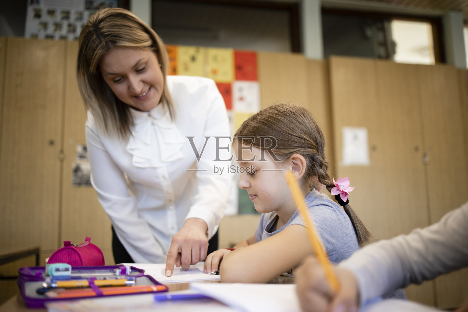 白人教师在课堂上帮助孩子完成作业。照片摄影图片