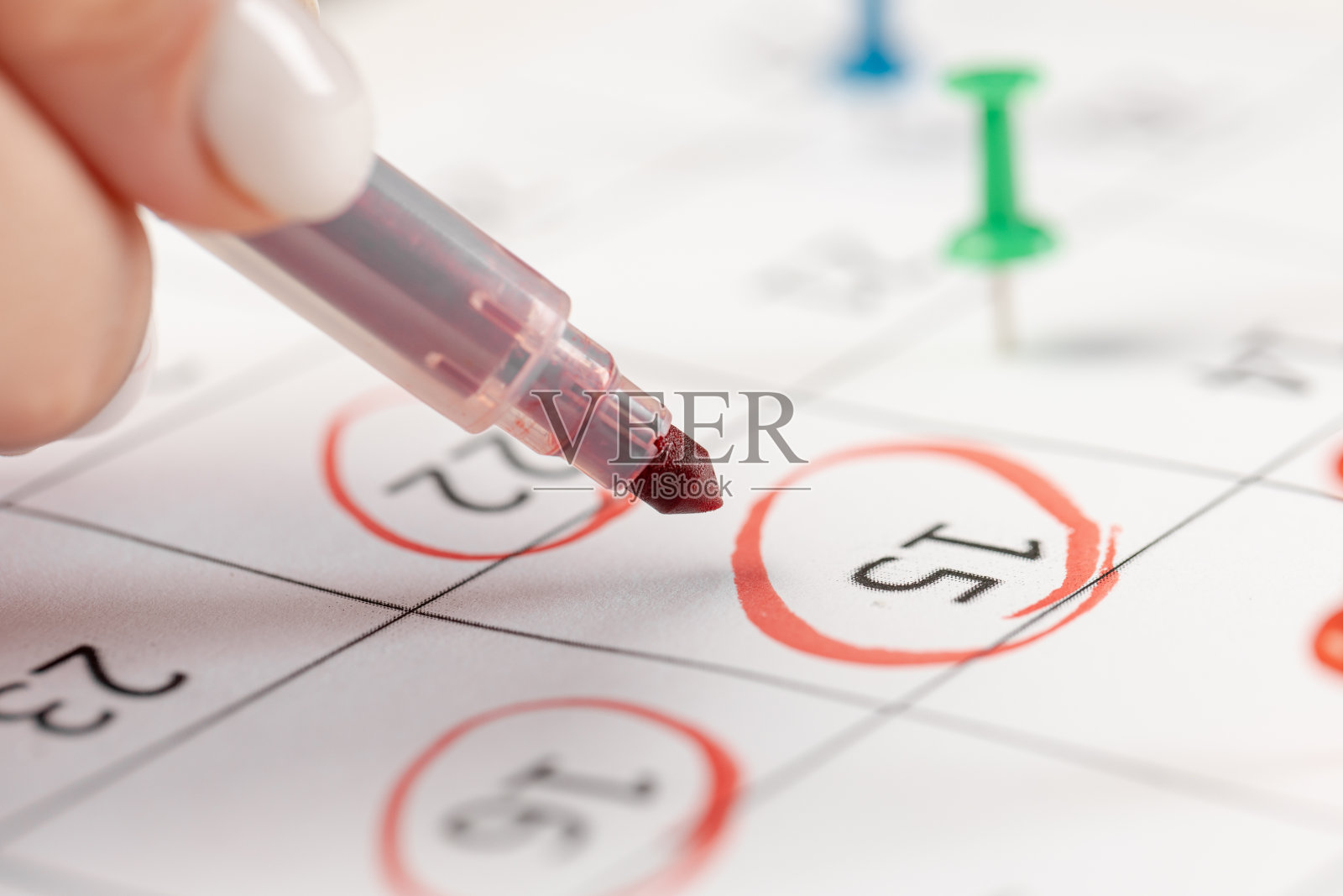 女性手印用红色记号笔在日历上标注一个重要事件的几个销钉记号照片摄影图片