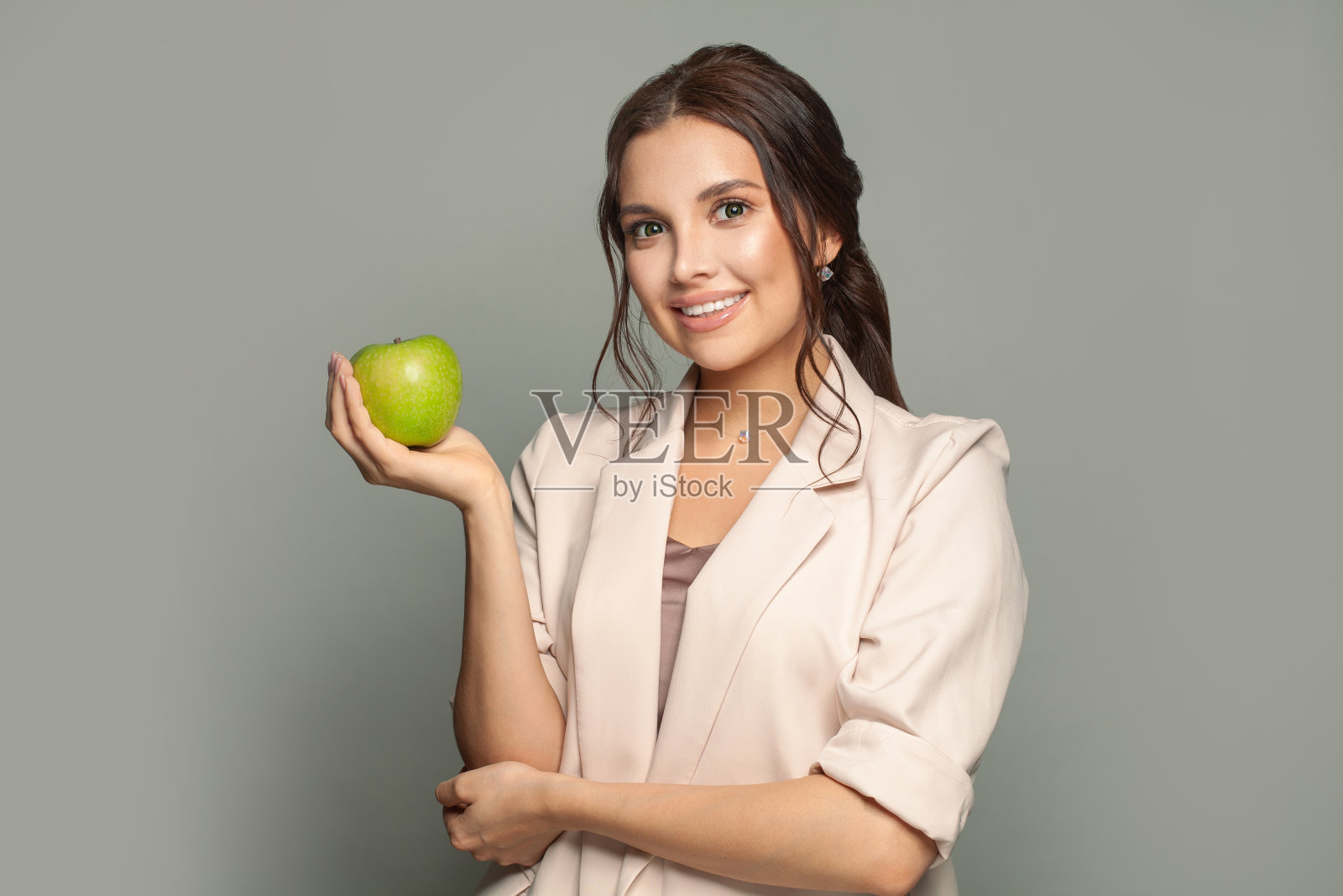 一个年轻快乐的女商人拿着青苹果的肖像照片摄影图片