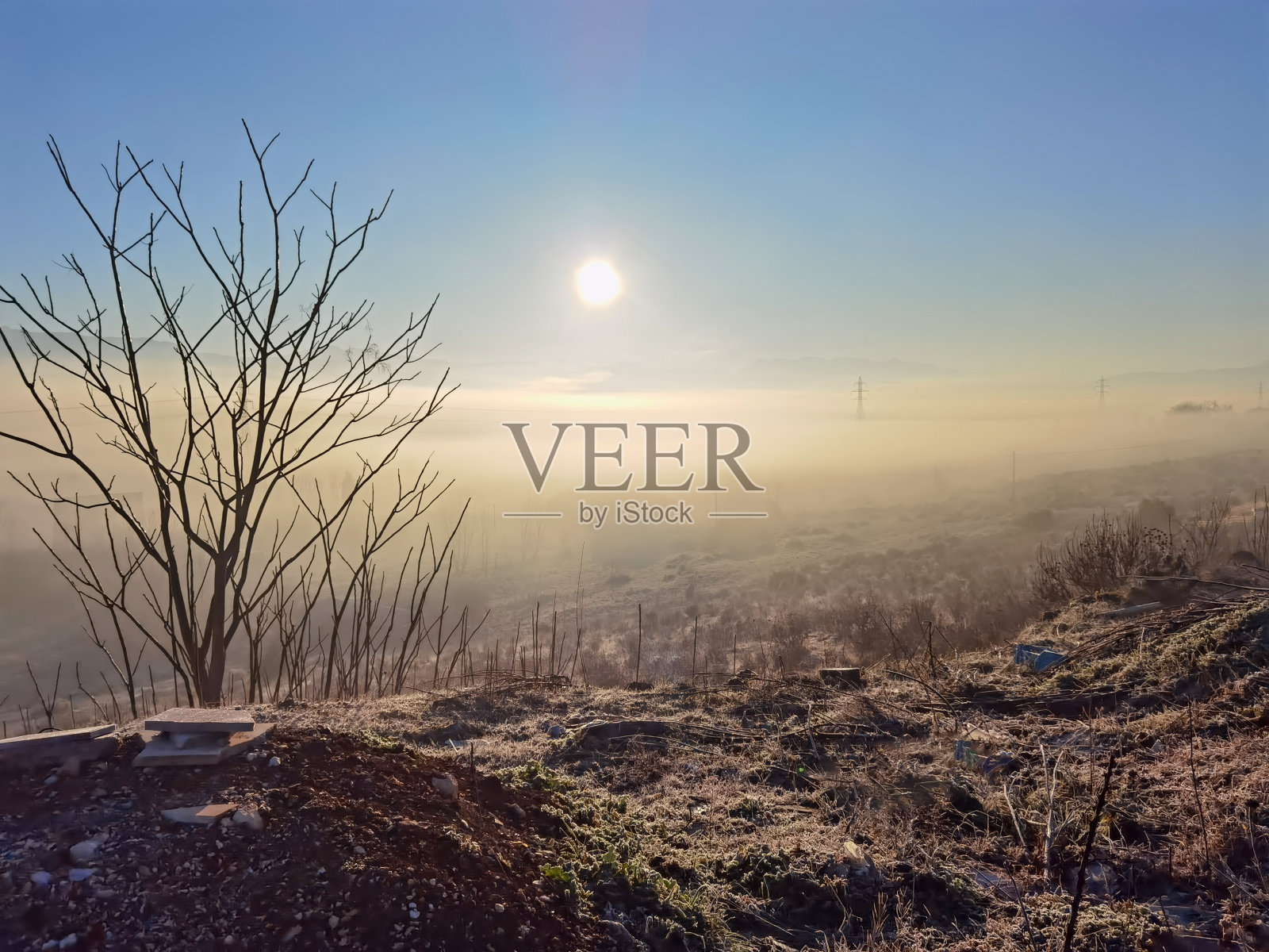 希腊约阿尼纳州斯塔夫拉基村的电塔晨雾中，太阳升起照片摄影图片