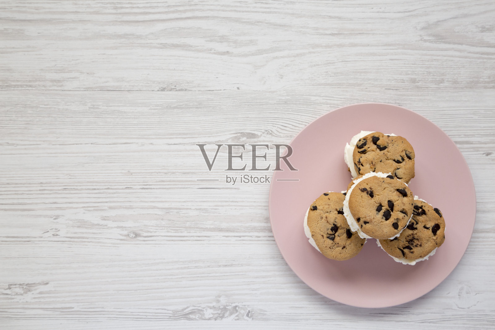 自制巧克力饼干冰淇淋三明治在一个粉红色的盘子上白色的木制背景，俯视图。头顶上，从上面，平躺着。副本的空间。照片摄影图片