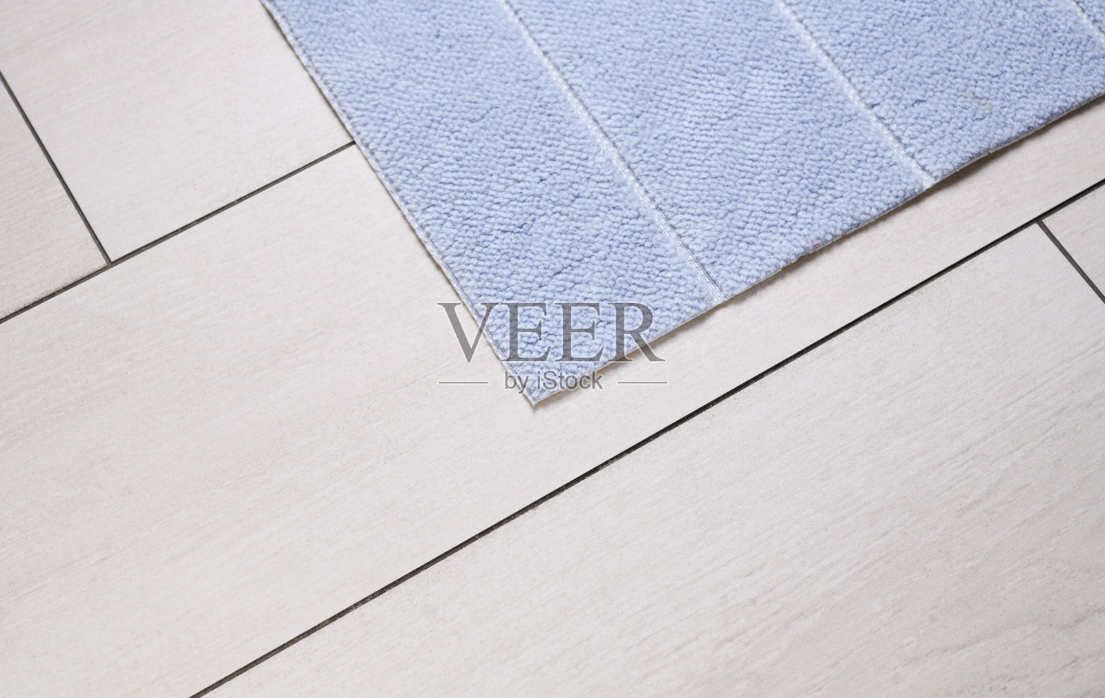 蓝色地毯在白色瓷砖与木材纹理。从以上观点。照片摄影图片