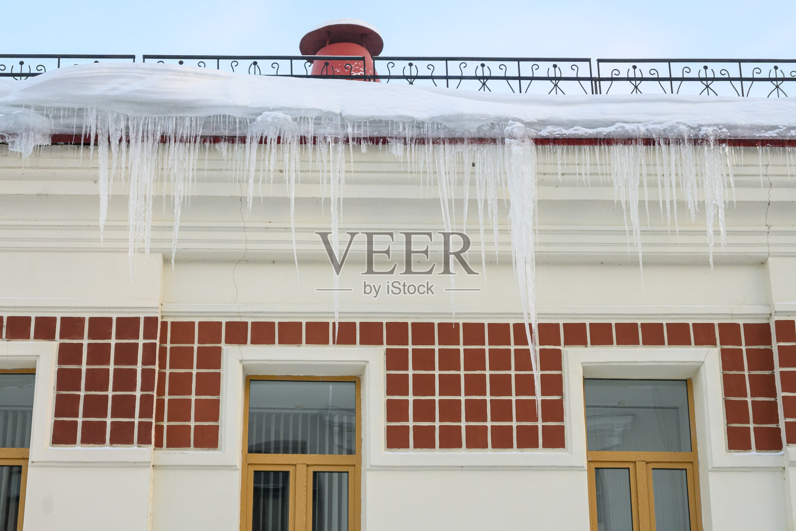 危险地悬挂在屋顶上的冰柱照片摄影图片