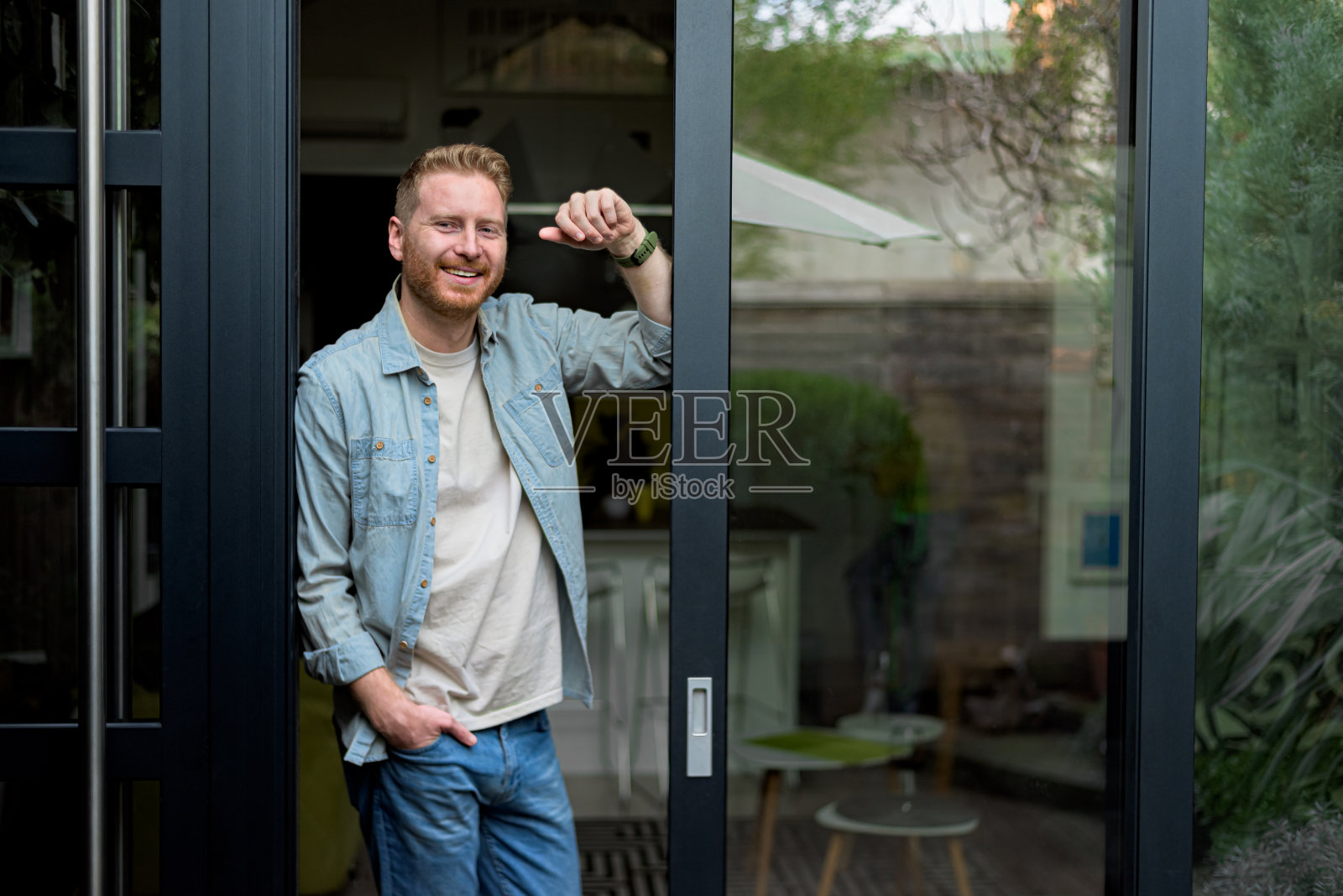 愉快的高兴的满意的微笑的商人或商人成功的会议后。一个成年人站在门口，满面春风，快乐无比照片摄影图片