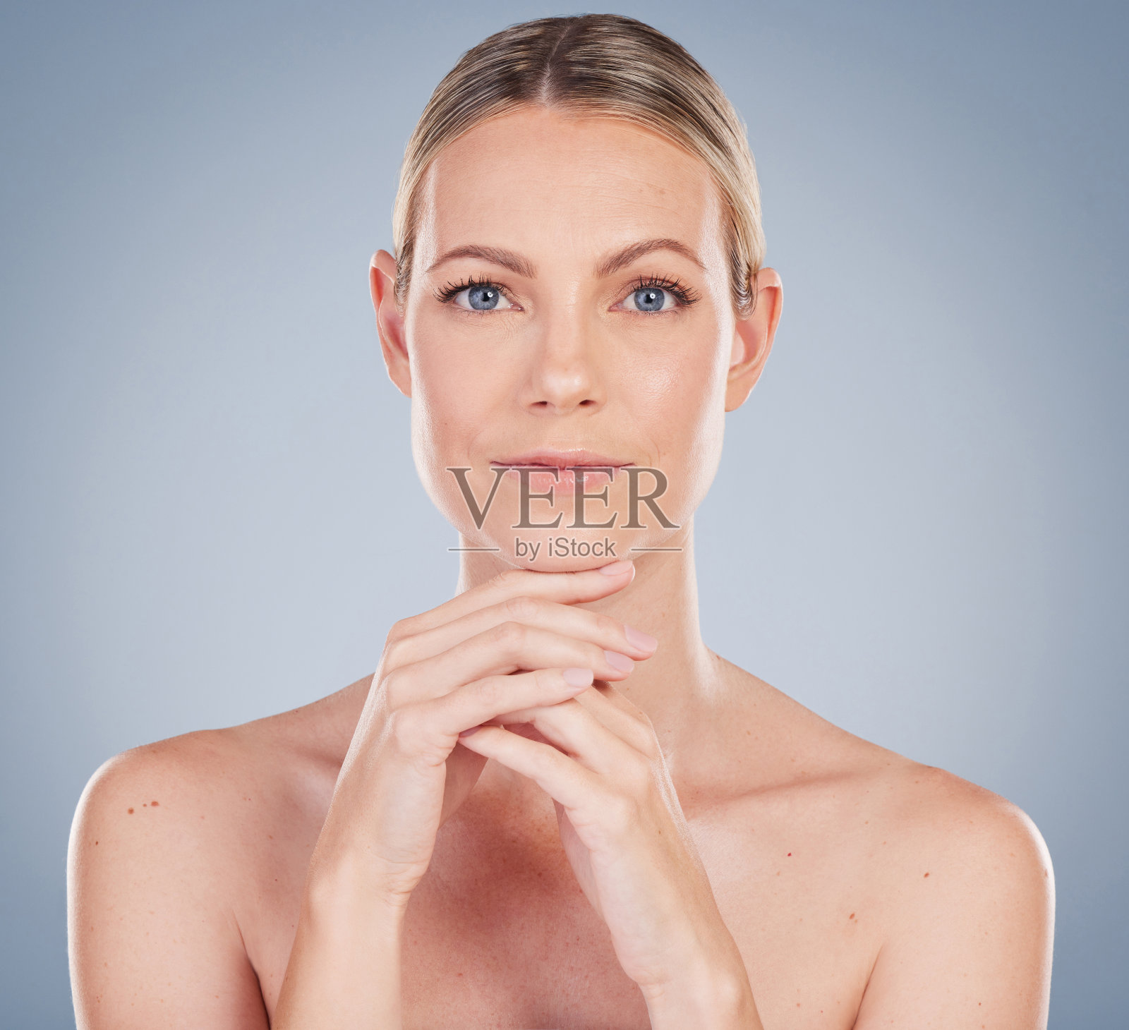 一个迷人的年轻女子在灰色背景下摆姿势的工作室肖像照片摄影图片