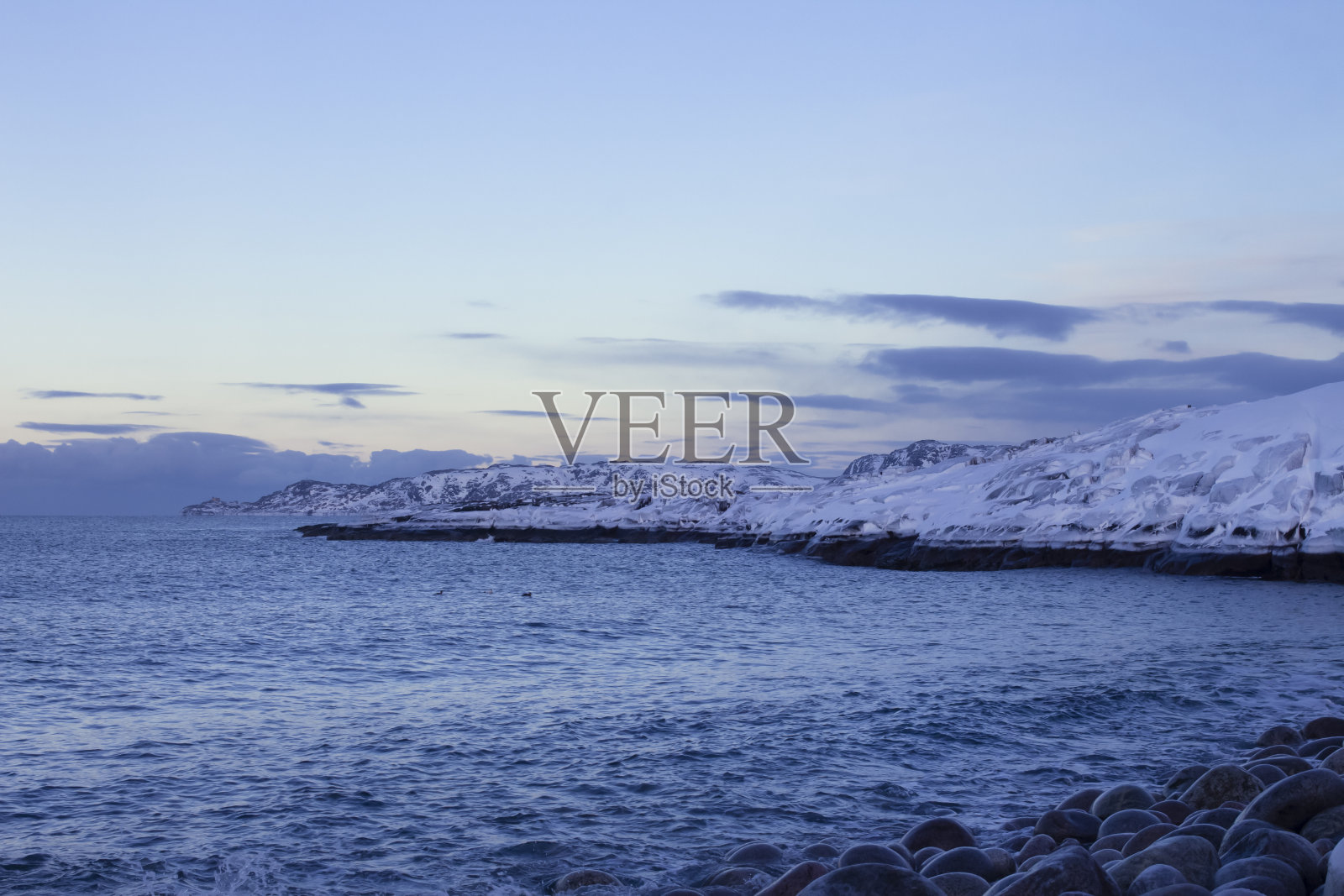 冬天的海景。白雪覆盖的岩石海岸。大海和蓝天。俄罗斯，捷里别尔卡，科拉半岛。照片摄影图片