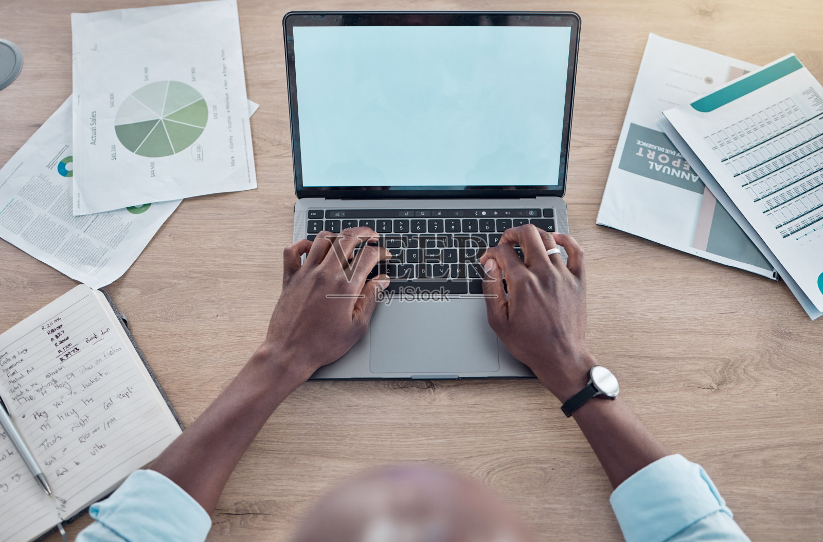 一个商人在他的桌子上用他的笔记本电脑工作的照片照片摄影图片