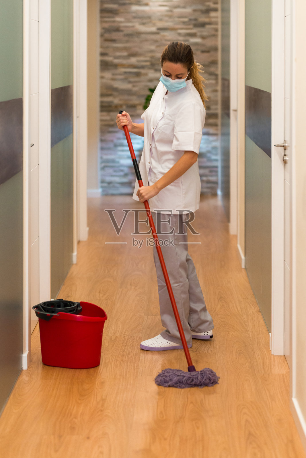 在现代医疗诊所里给地板消毒的女人照片摄影图片