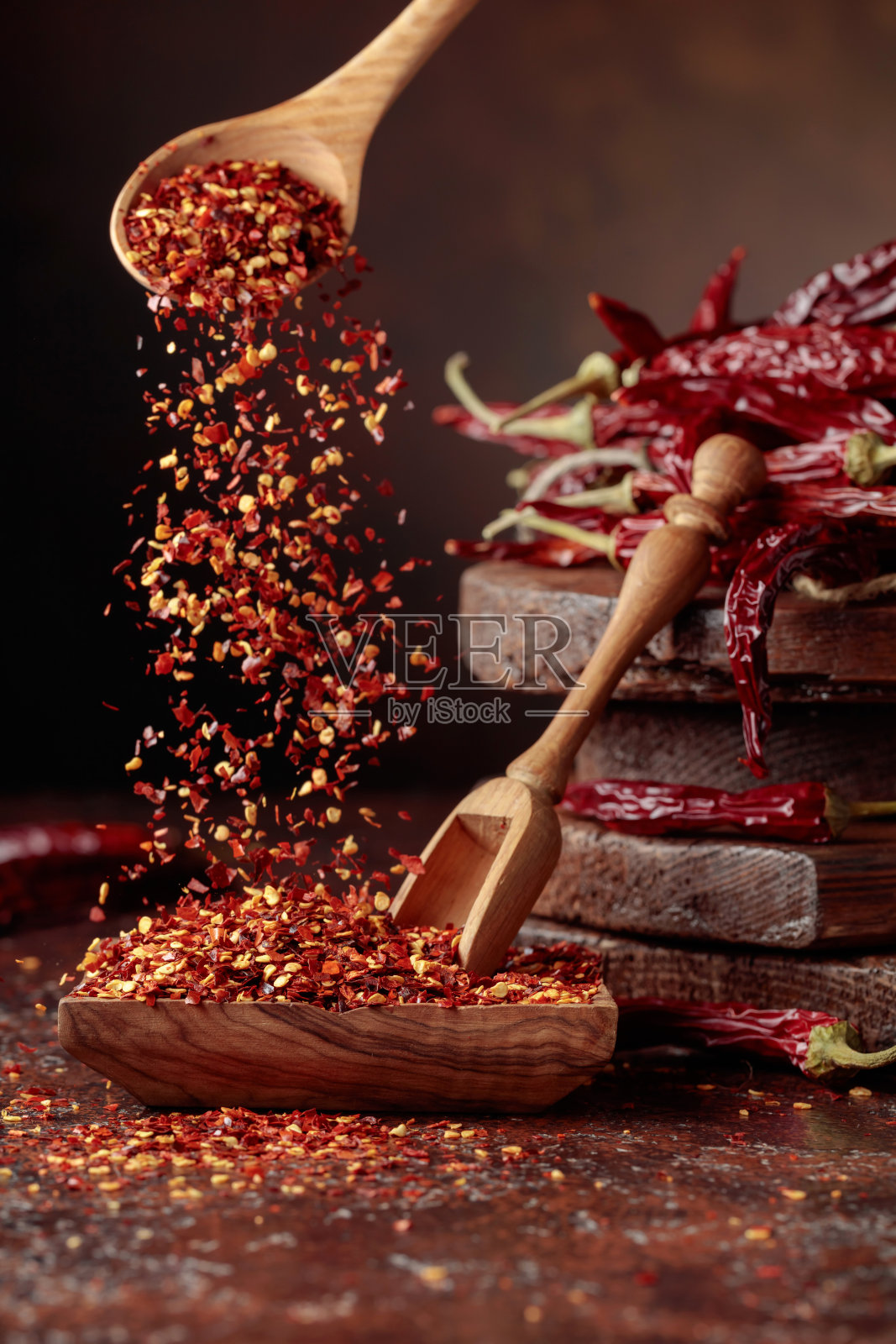 辣椒片倒进木盘里。照片摄影图片