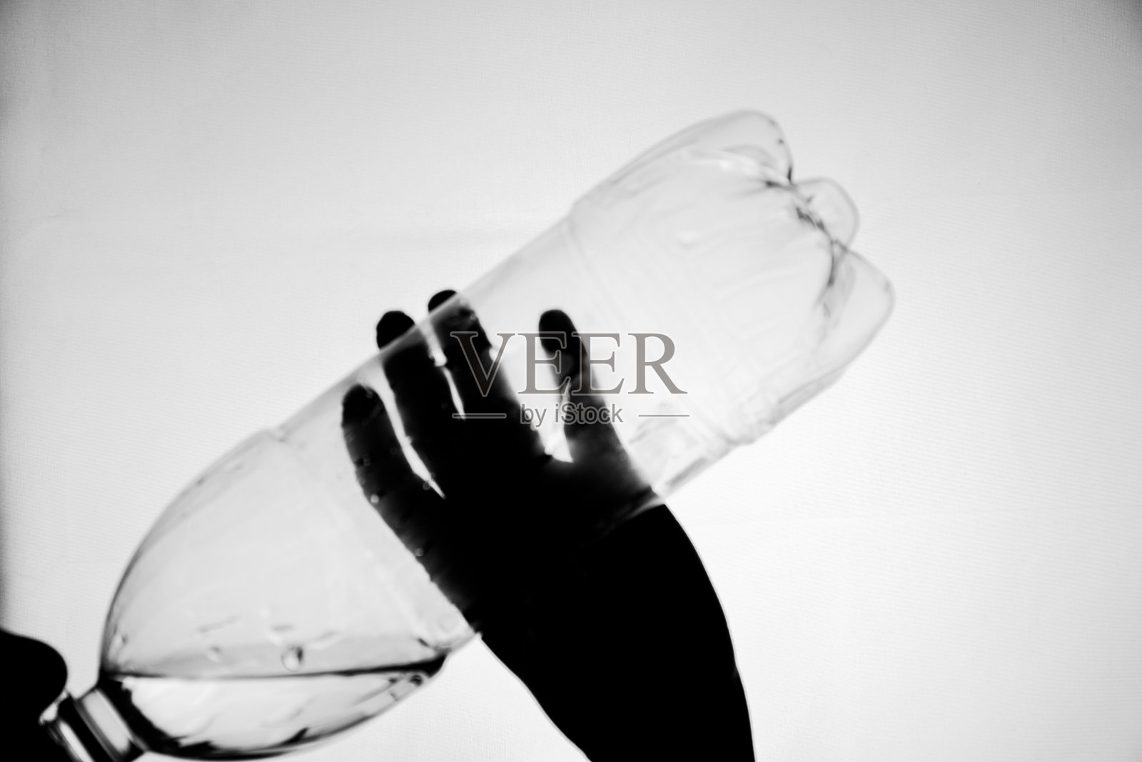 一个人从瓶子里喝水的剪影照片摄影图片