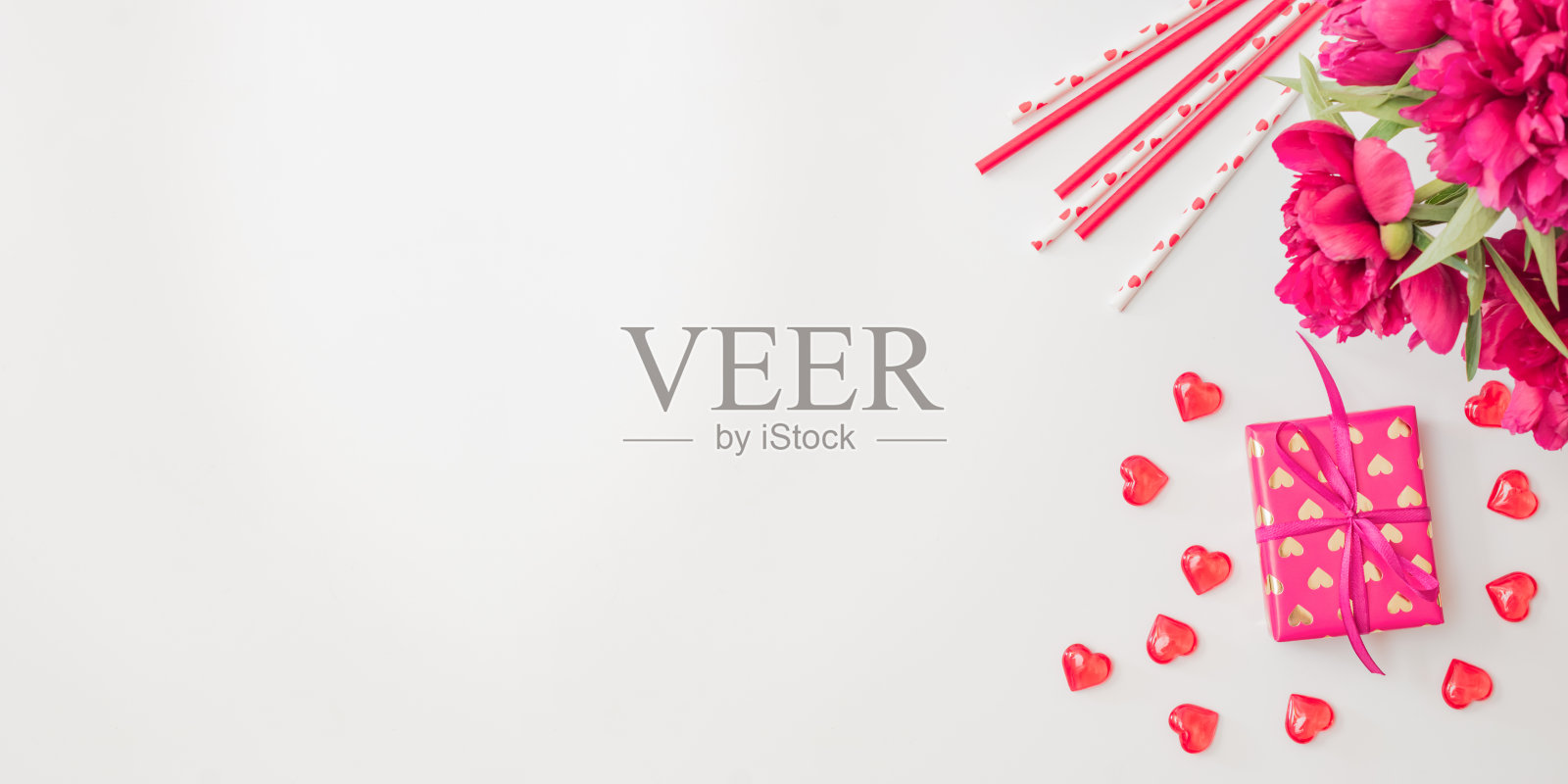 平躺情人节框架与红色牡丹，礼盒和红心在一个白色的背景。情人节横幅与复制空间照片摄影图片